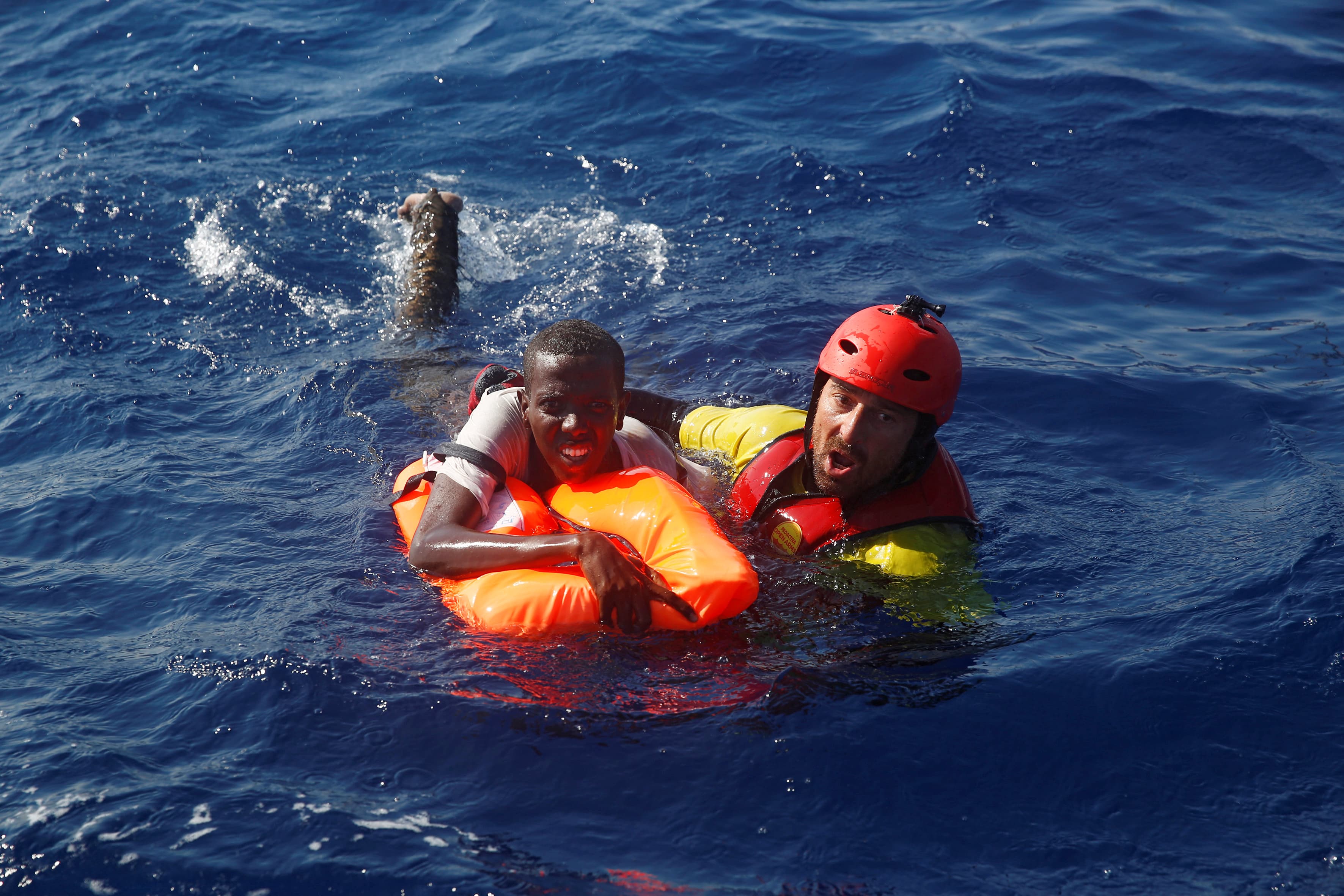 A member of the Spanish NGO Proactiva rescues a Somali migrant that fell from an overcrowded dinghy, during a rescue operation off the Libyan coast in Mediterranean Sea August 28 , 2016. REUTERS/Giorgos Moutafis