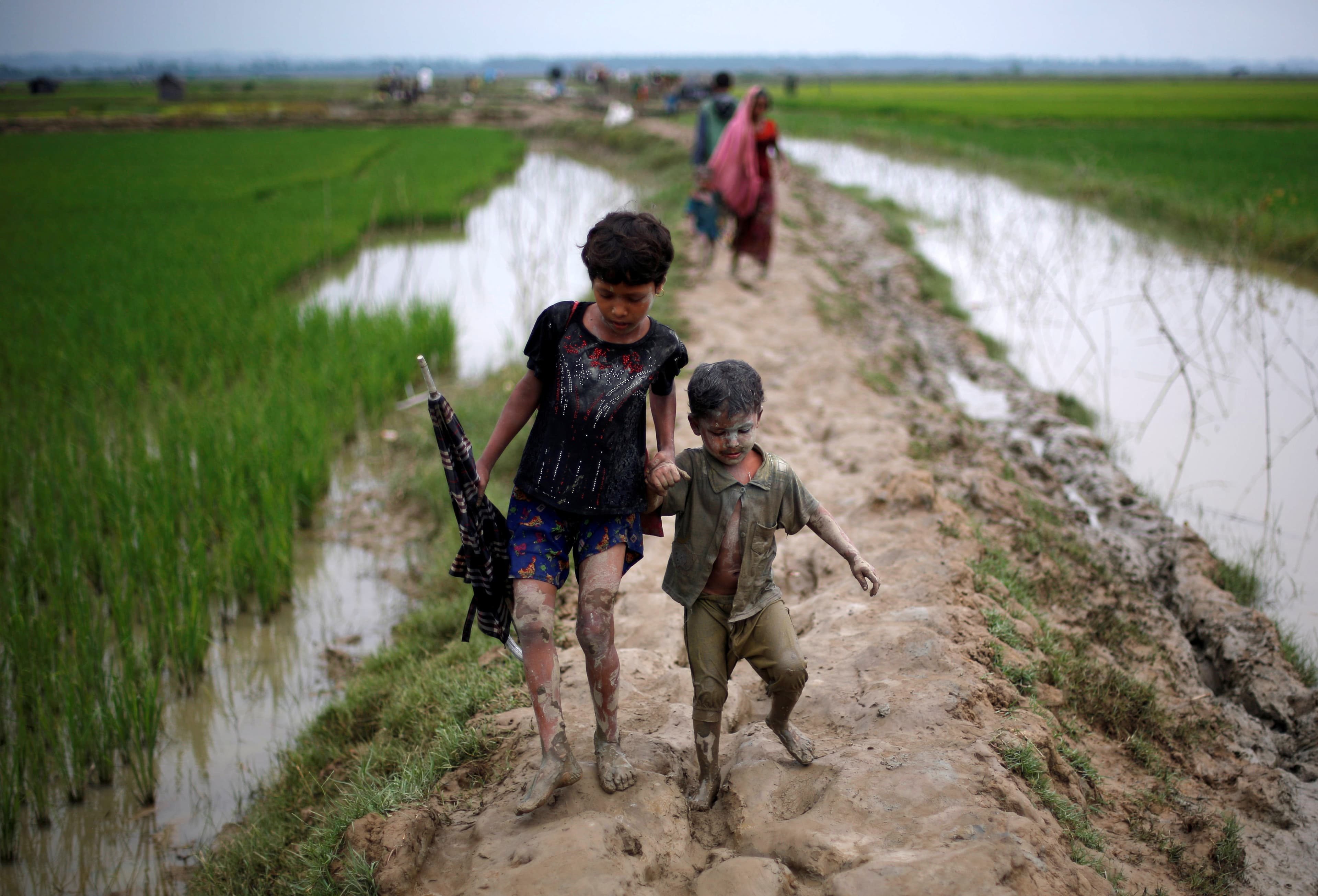 Rohingya refugee children walk on a muddy path after crossing the Bangladesh-Myanmar border, in Teknaf, Bangladesh, Sept. 6, 2017.