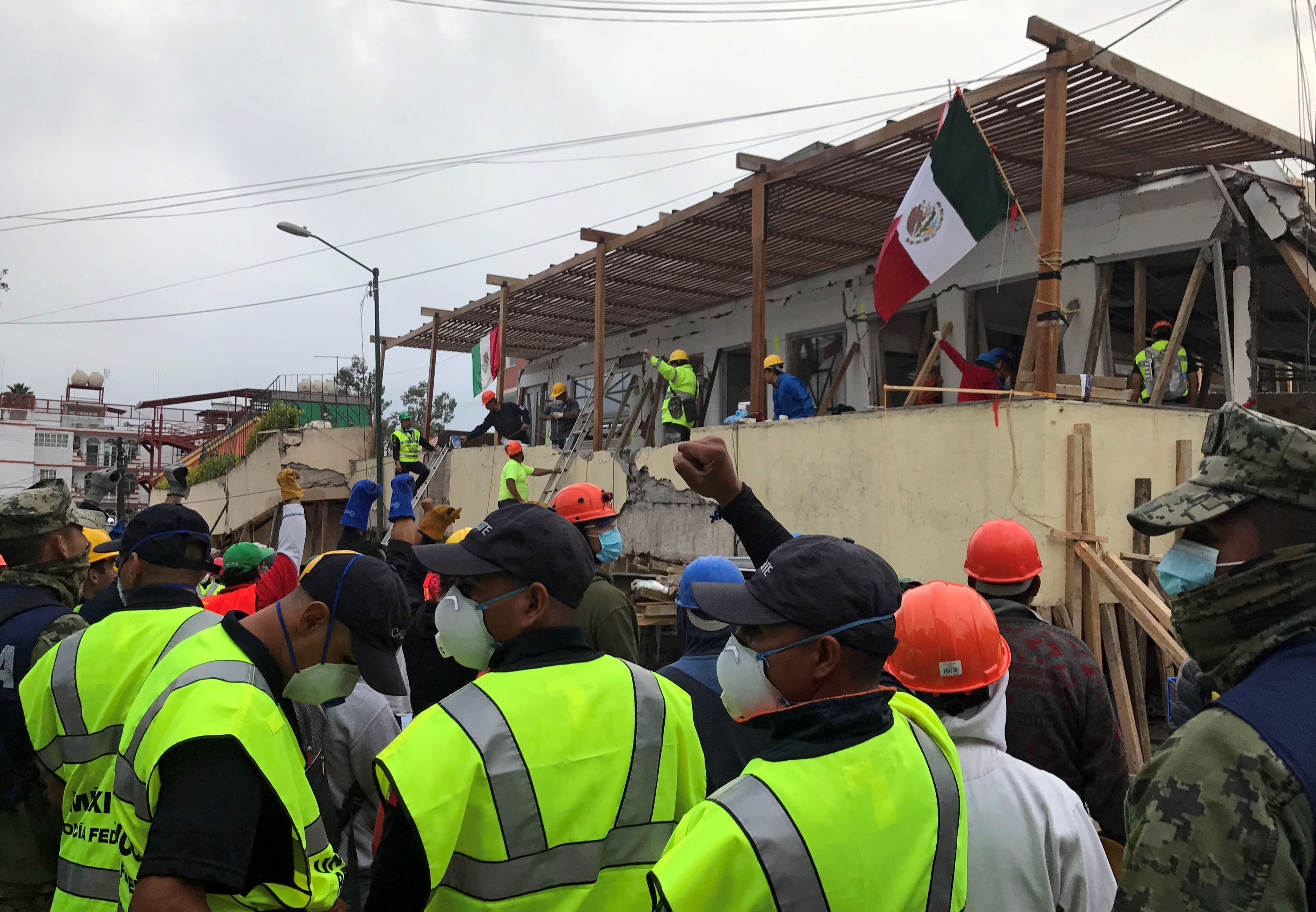 Soldiers and rescue workers gesture for people to be quiet as they search in the rubble for students of the Enrique Rebsamen school after an earthquake hit Mexico City, on Sept. 20, 2017.