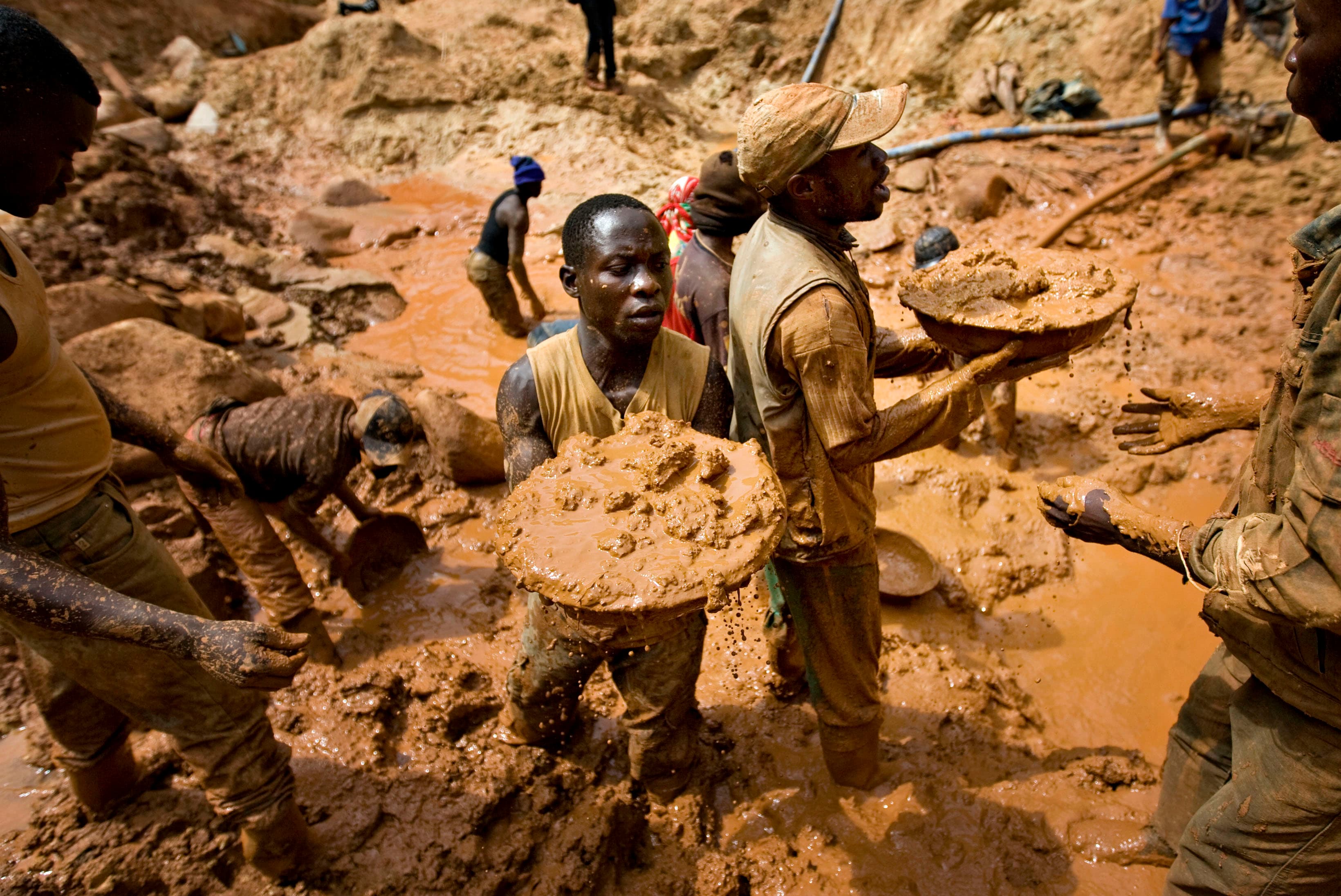 Gold miners form a human chain while digging an open pit at the Chudja mine near the village of Kobu, in northeastern DRC, Feb. 23, 2009.