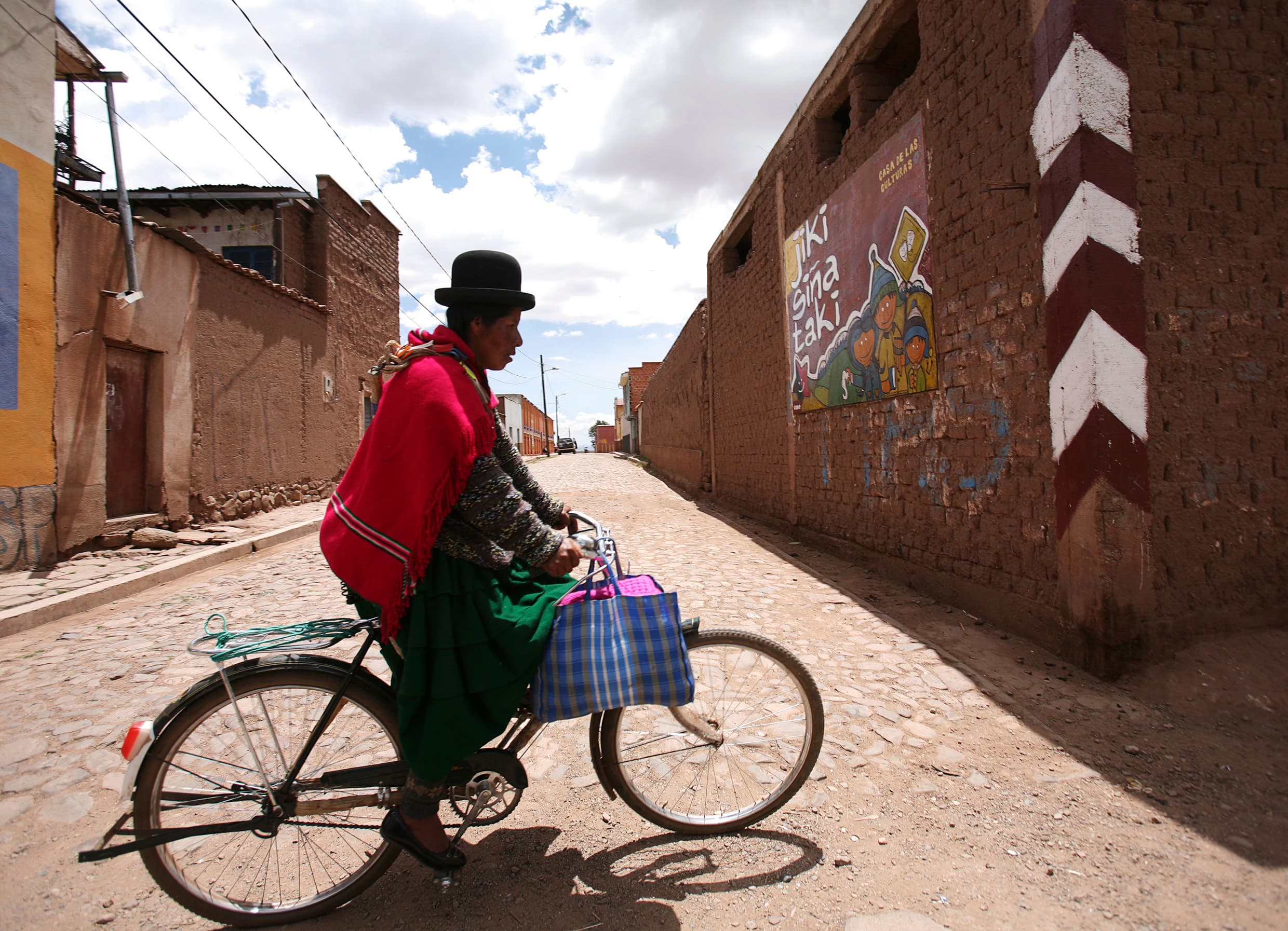 An Aymara woman rides her bicycle in Tiwanaku, a UNESCO world heritage site about 40 miles west of La Paz near the shores of Lake Titicaca, 2012.