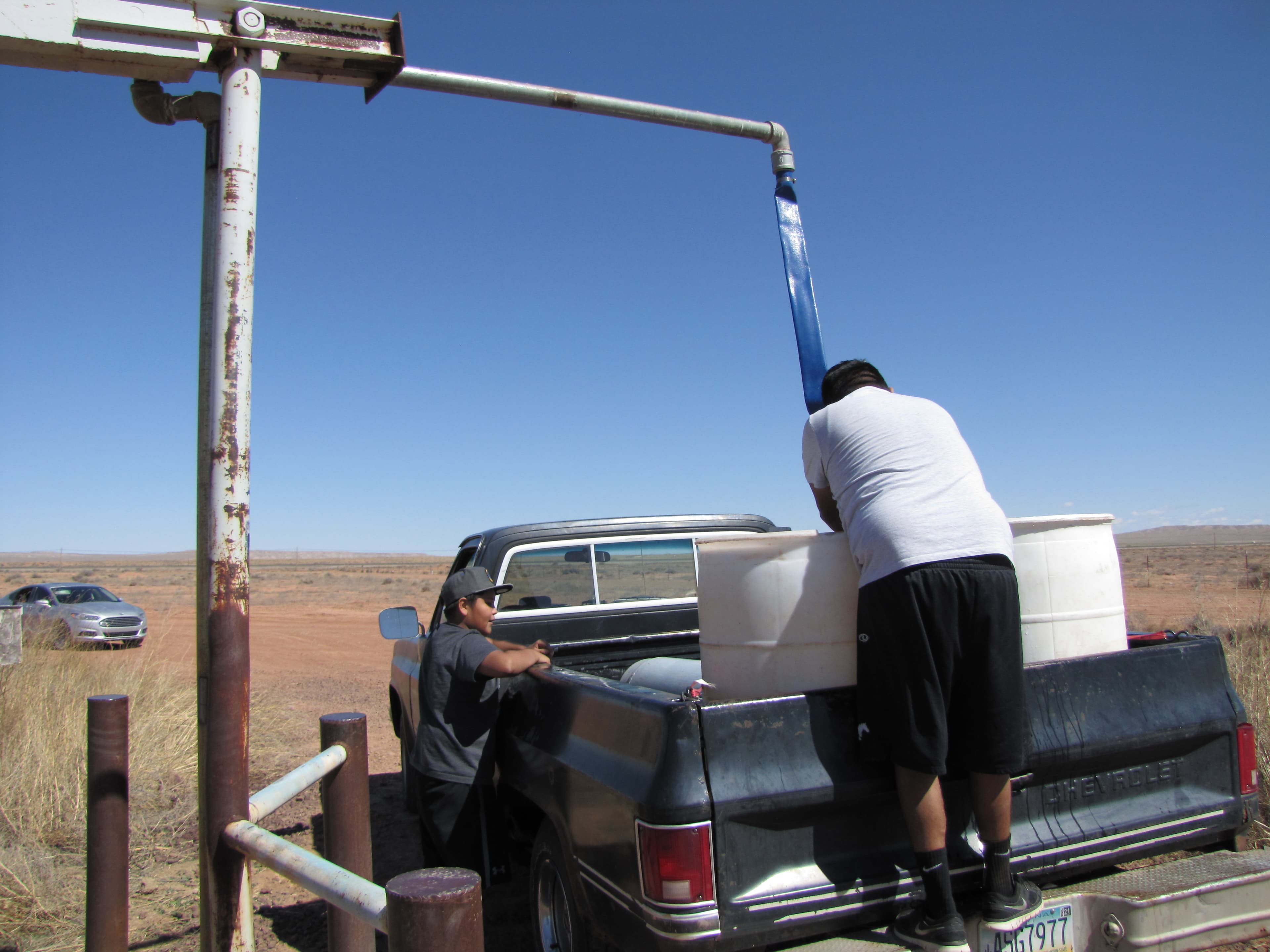Sterling and Brennan Begay fill up water barrels for their livestock at a watering station in Bird Springs, Arizona. They have to travel even farther from their homes to get potable water for people. 40 percent of the residents of the Navajo Nation lack r