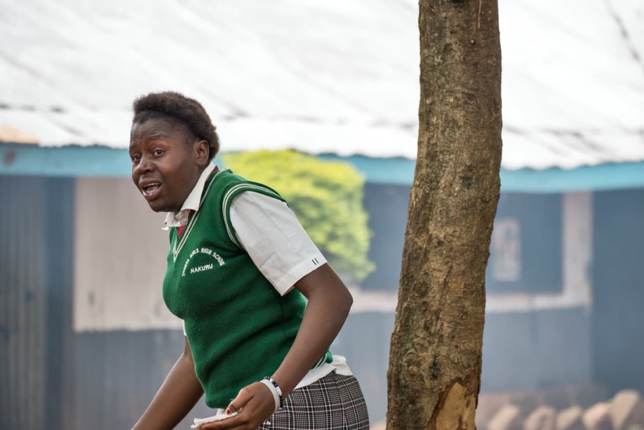 A student runs from Silver Spring Secondary School after a tear-gas canister landed inside the compound.