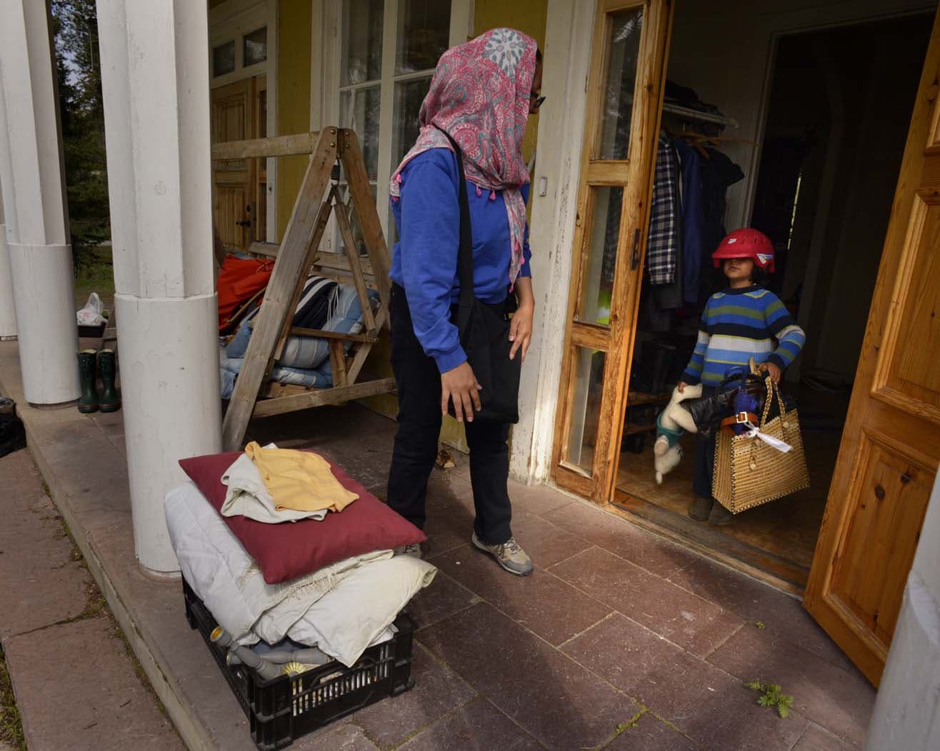 A family from Palestine carries second hand items from a local villager’s home