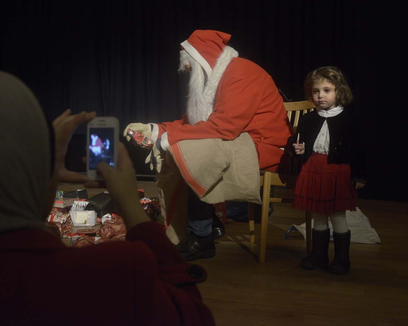 A Swedish Christmas tradition of handing out gifts becomes a photo opportunity for a newly arrived family from Syria.