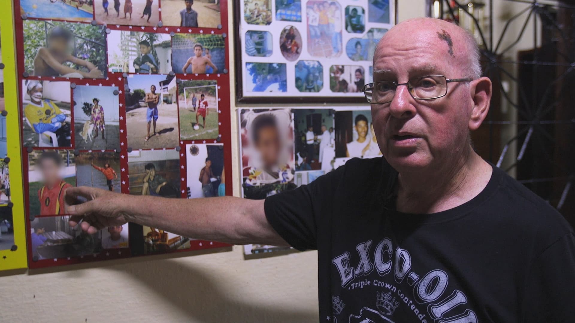 Father Jan Van Dael shows off his collection of portraits — most of young boys — on the veranda outside his home. The building once housed orphans, but Van Dael closed that operation down two years ago.