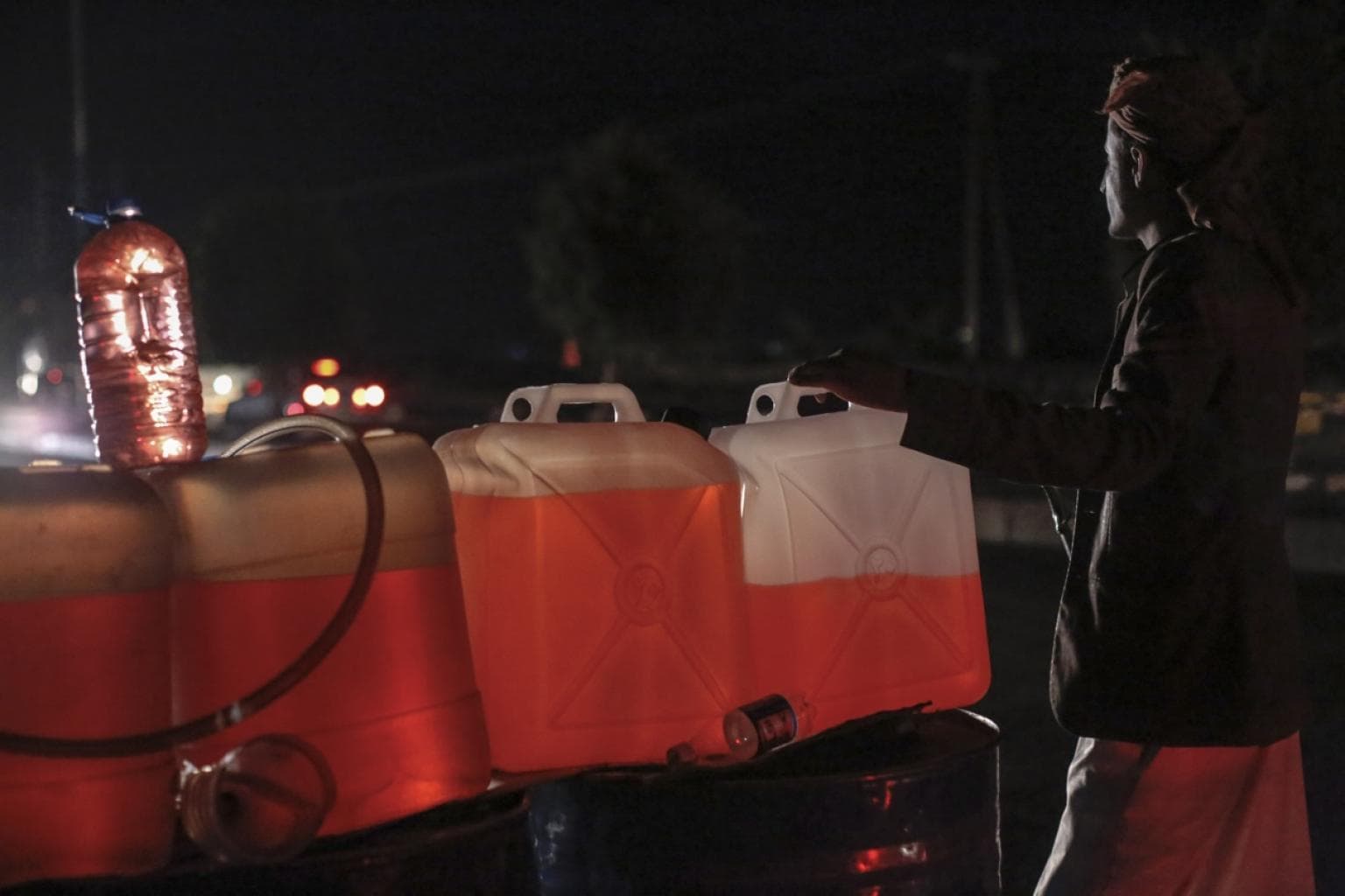 A man sells black-market fuel near in Sanaa, the capital of Yemen. The Saudi blockade has led to skyrocketing fuel prices. In some parts of the country, the price of fuel is 400 percent higher than what it was before the war.