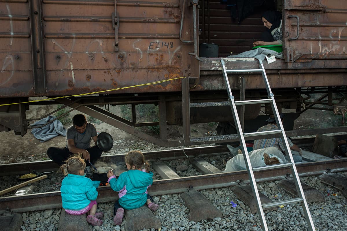 Twins Mimi, left and Lulu Betula, 3, from Aleppo, Syria, live with their parents in a box car parked at Idomeni.