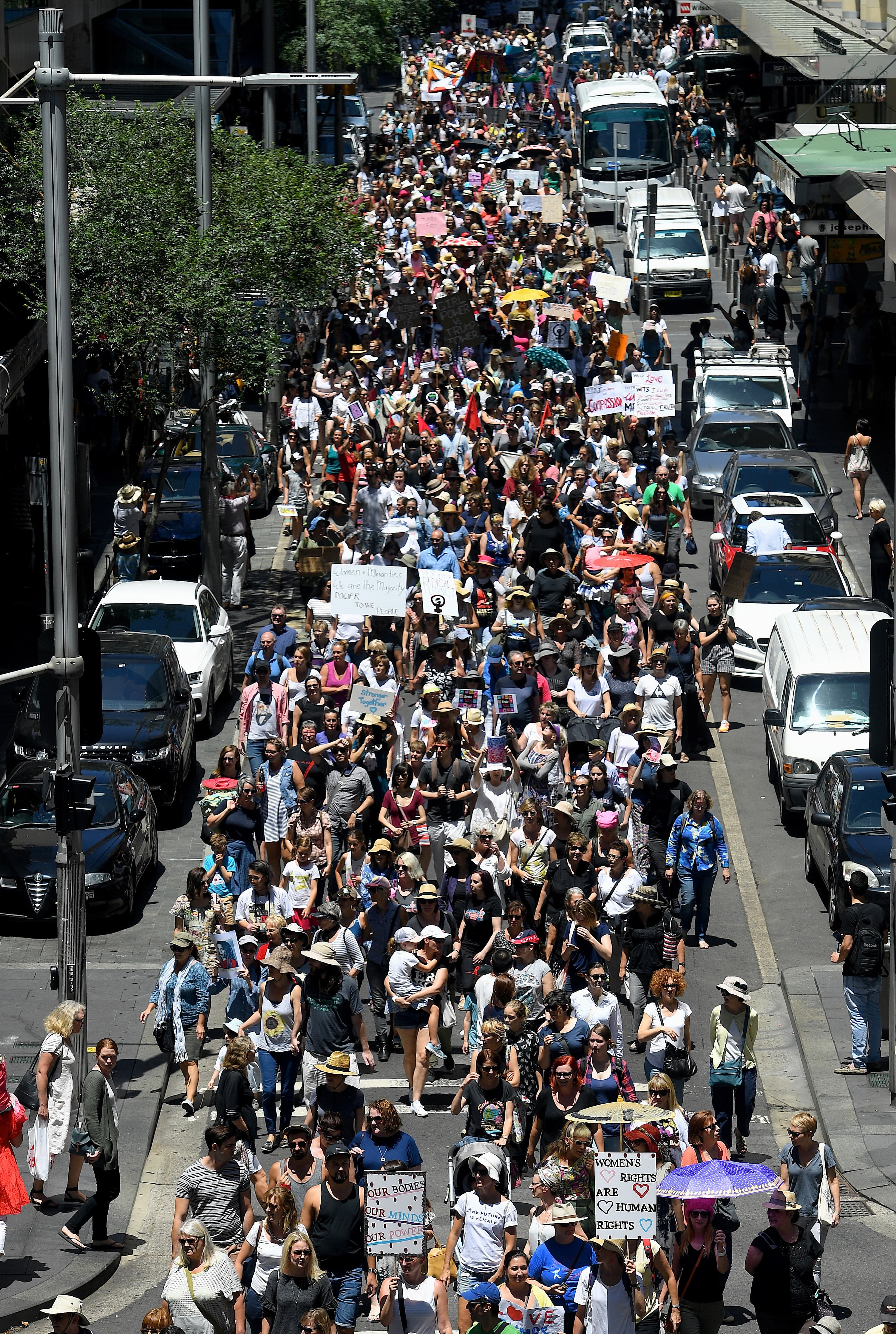 Protesters march along a main road during the first of hundreds of womens' marches organized around the world in a show of disapproval of US President Donald Trump