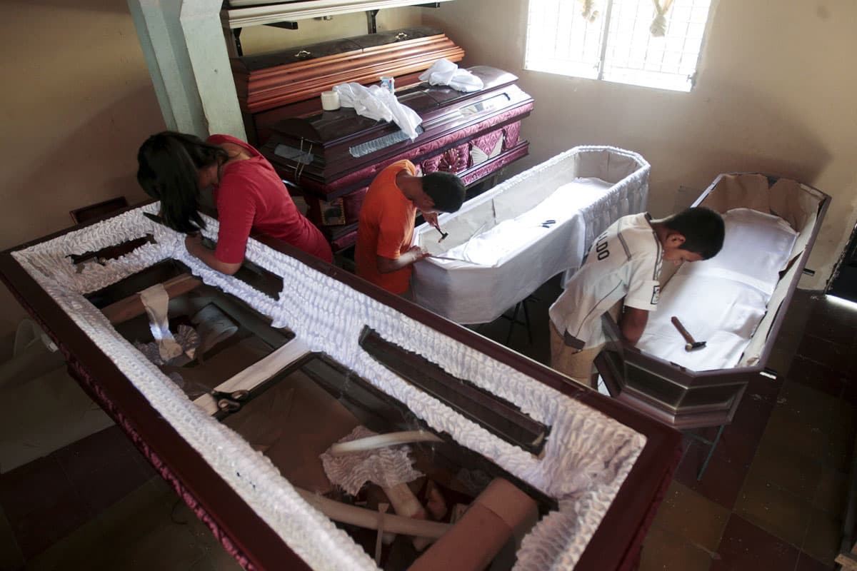 Children work on the lining of a coffin at El Nuevo Renacer factory in Jucuapa.