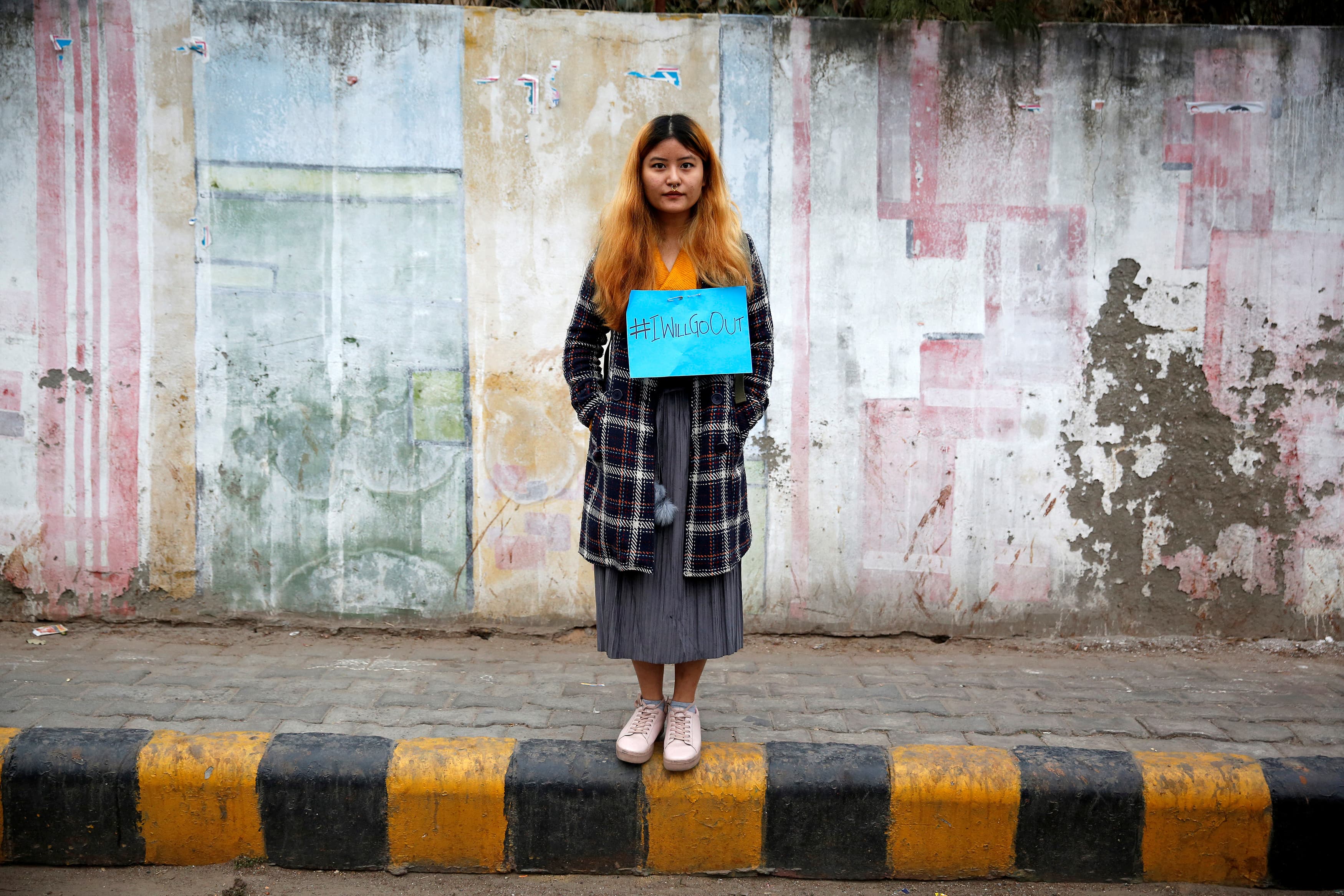 A woman waits for the start of the #IWillGoOut rally, organized to show solidarity with the Women's March in Washington, along a street in New Delhi, India