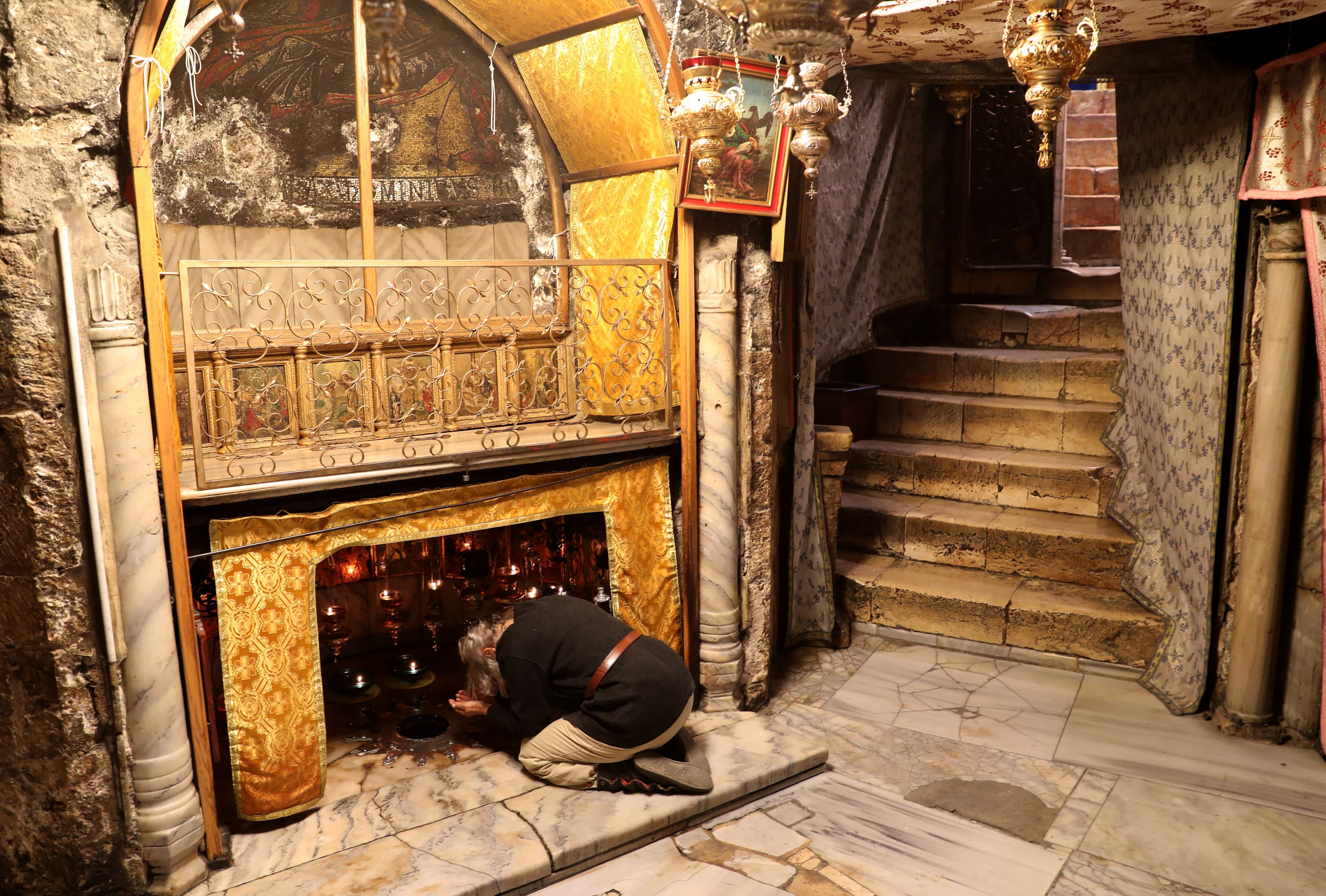 A woman prays in the grotto where Jesus Christ is believed to have been born at the Church of the Nativity in the West Bank city of Bethlehem, Dec. 19, 2017.