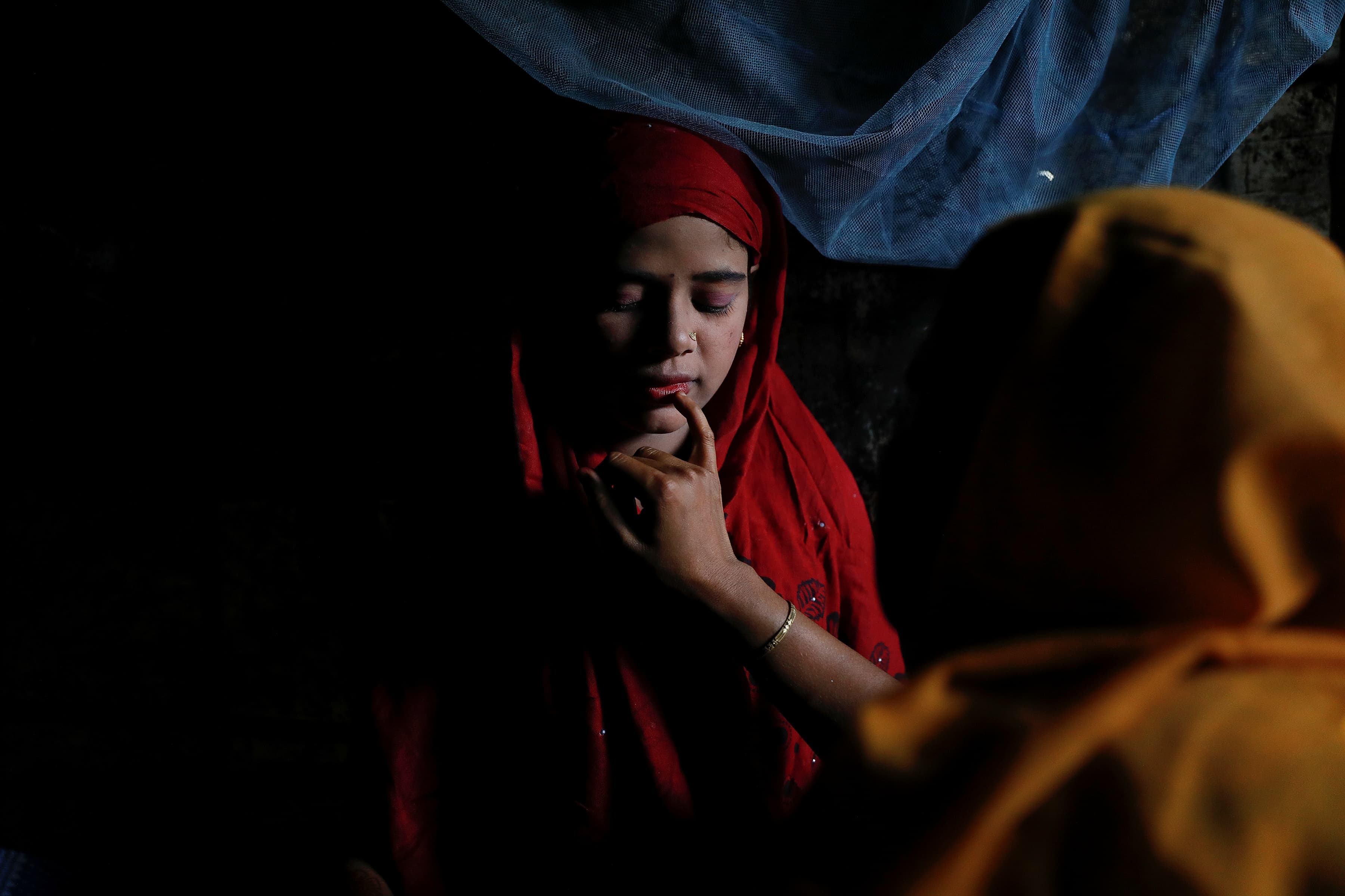 Shofika Begum is helped with make-up by her brother's wife on her wedding day.