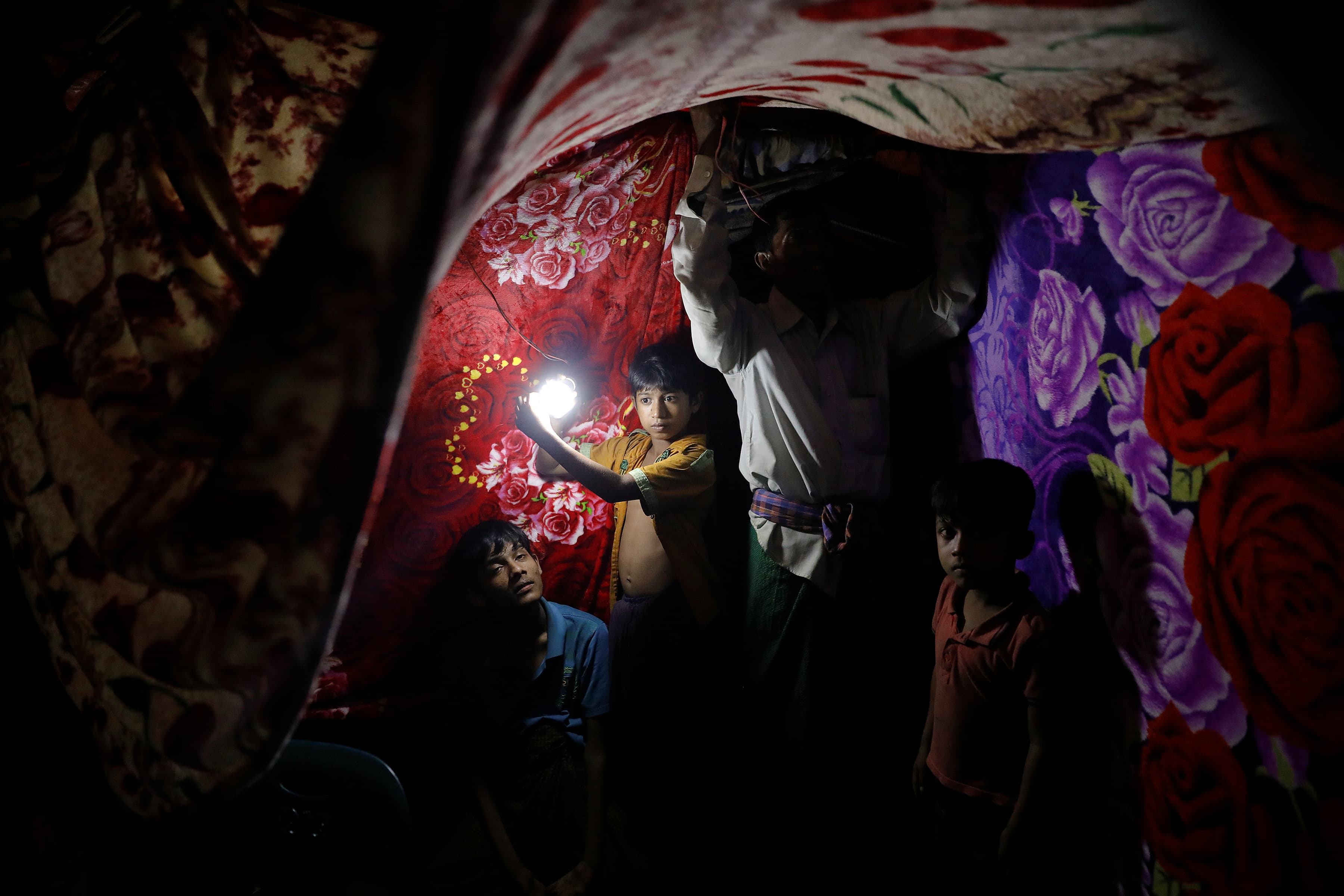 A refugee tent is decorated by colorful blankets for the wedding ceremony.