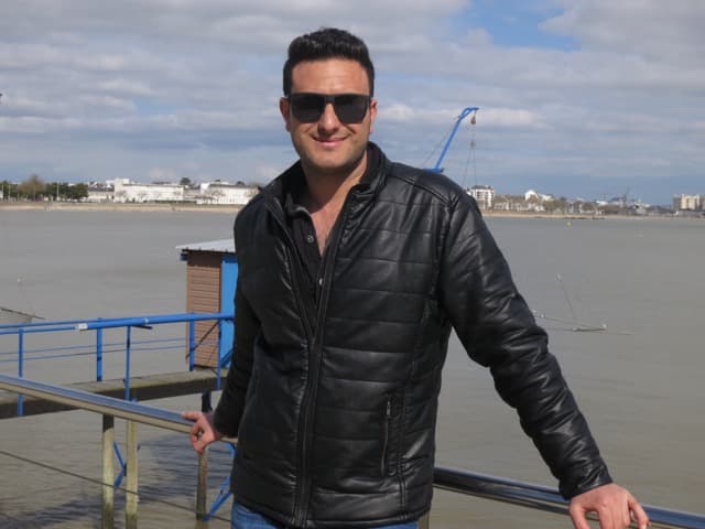 Salem Noh stands by the sea in Saint-Nazaire.