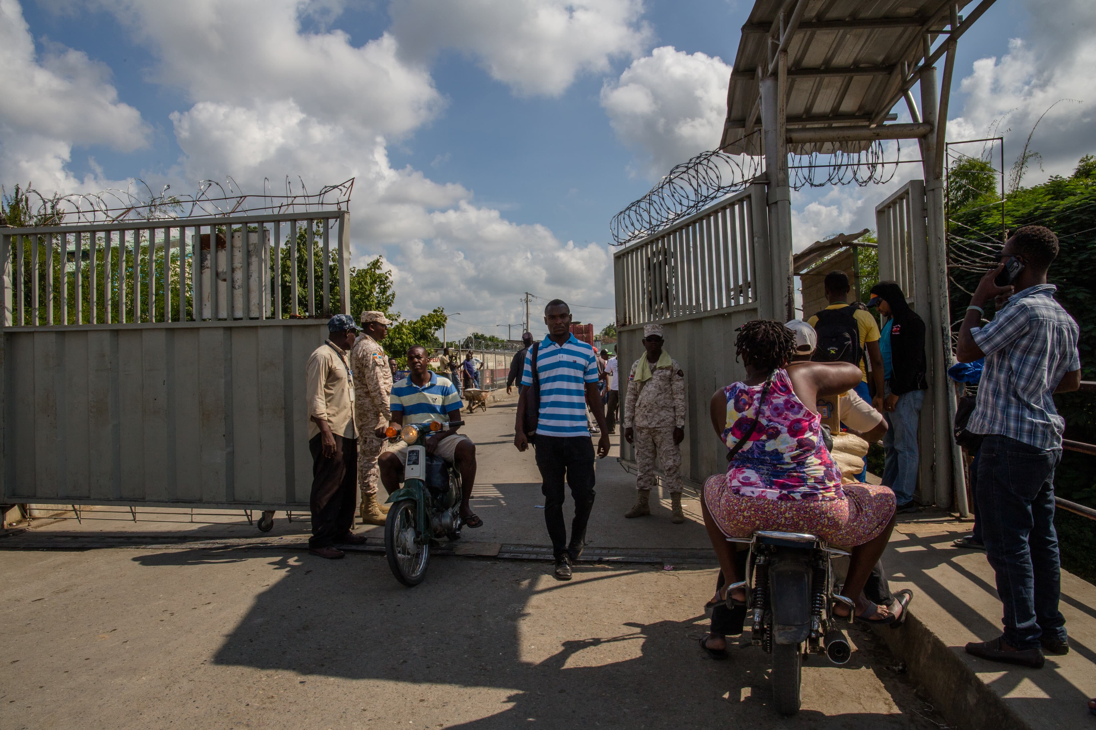 A woman on a motorcycle carries goods from the Dominican Republic into Haiti.