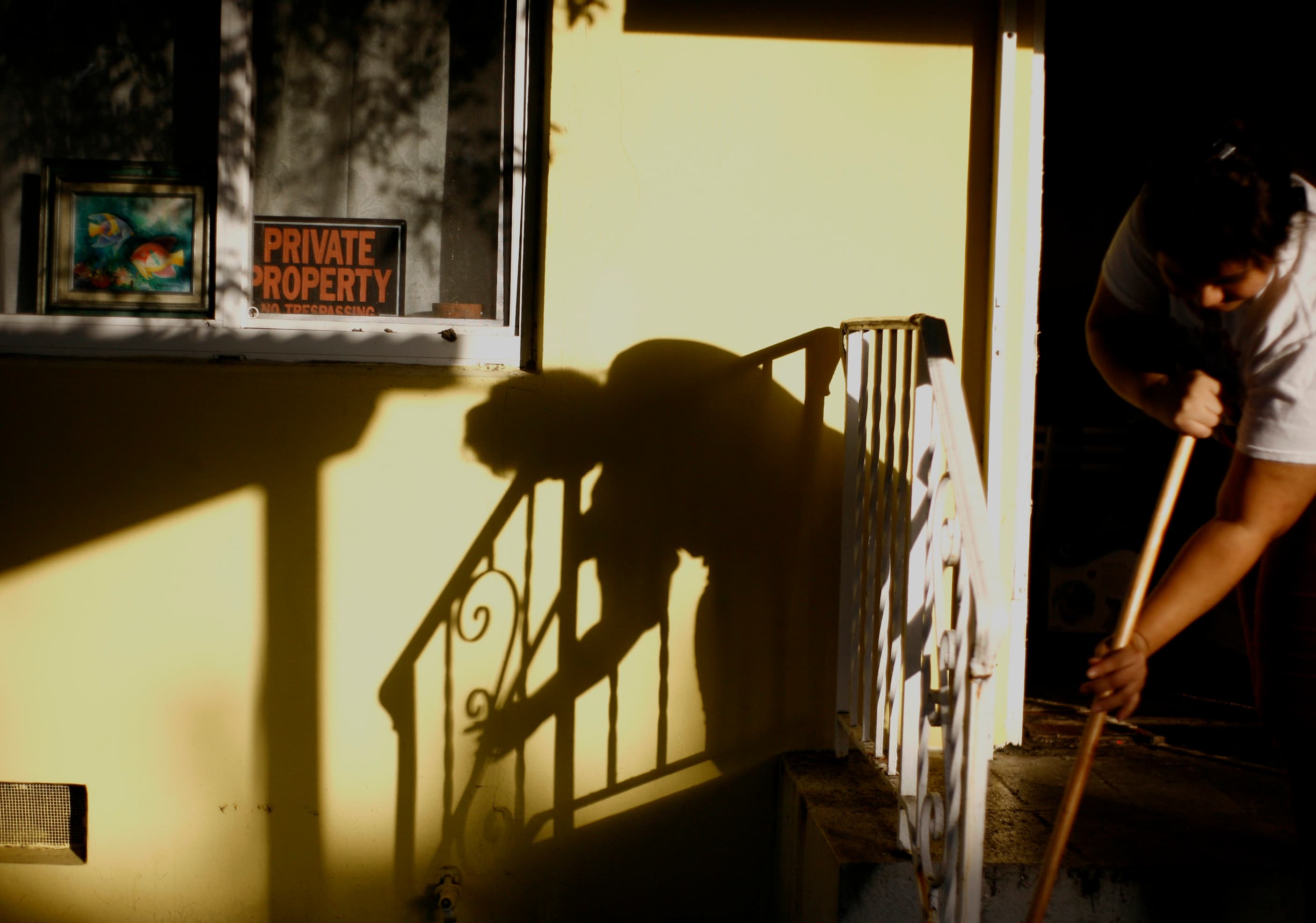 Person sweeping in front of building