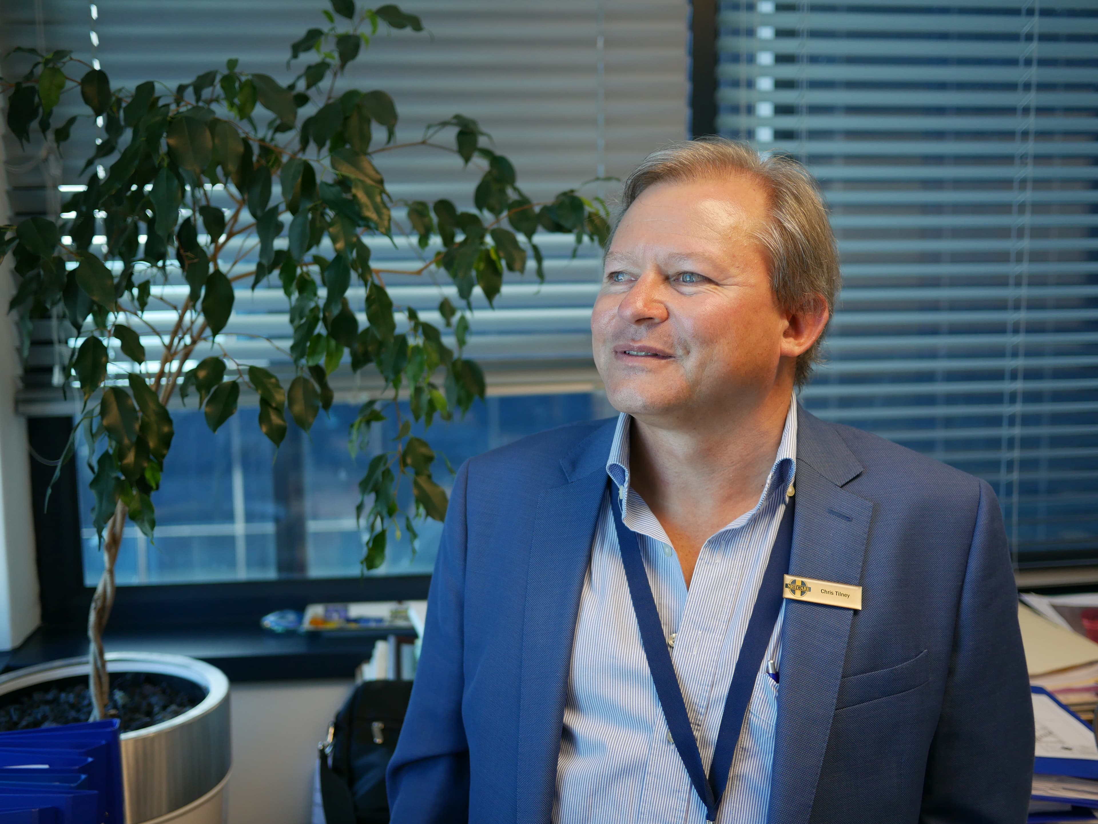 A portrait of Christiaan Barnard Hospital's General Manager Chris Tilney in a blue suit.