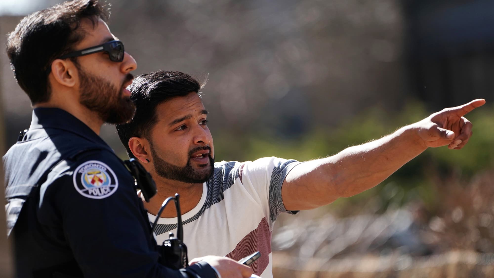 Police officer speaks with a witness after a van struck multiple people at a major intersection in north Toronto.