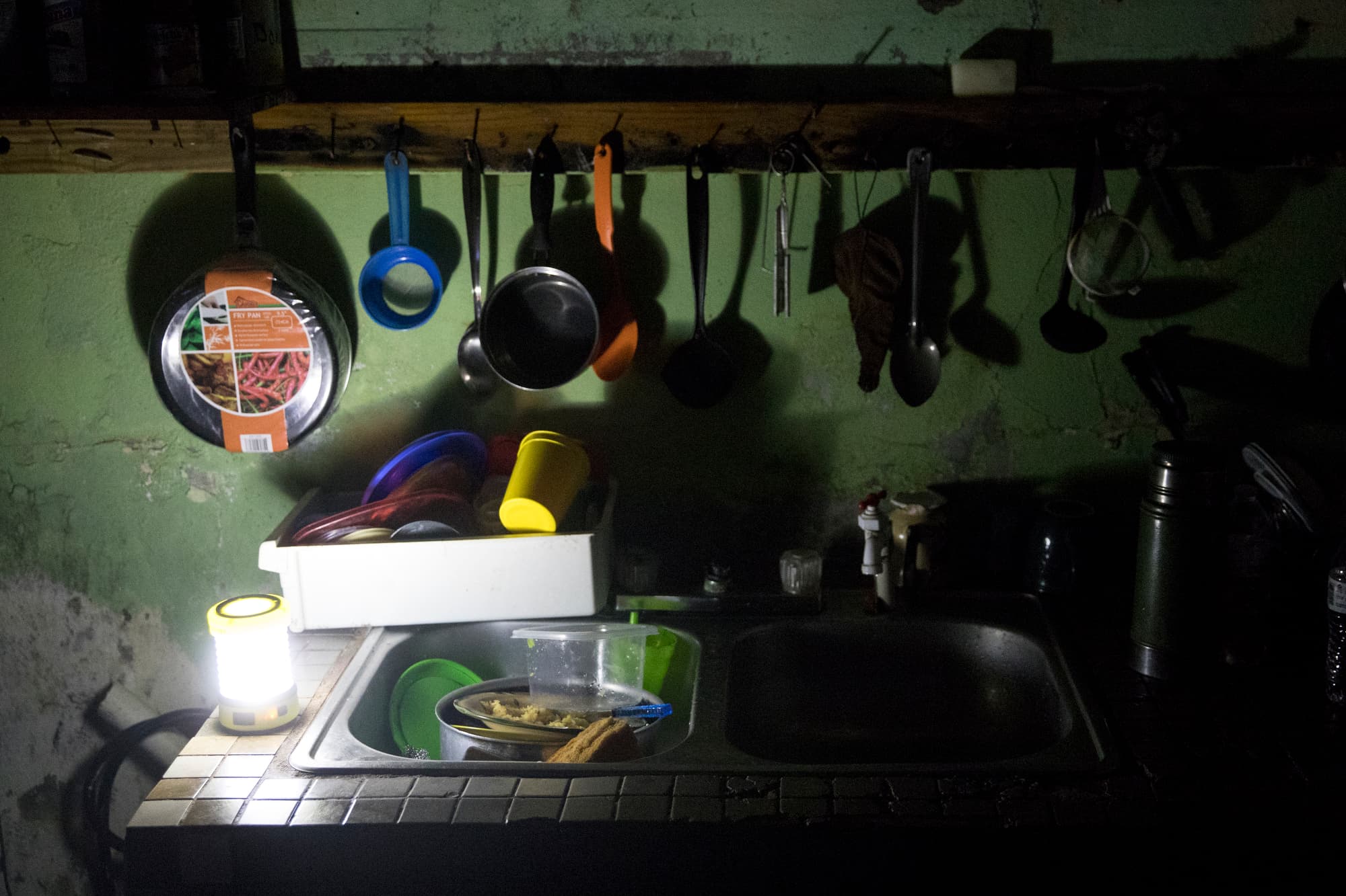The kitchen of Irma Torres and her husband Jose Morales is lit by a battery-powered lantern