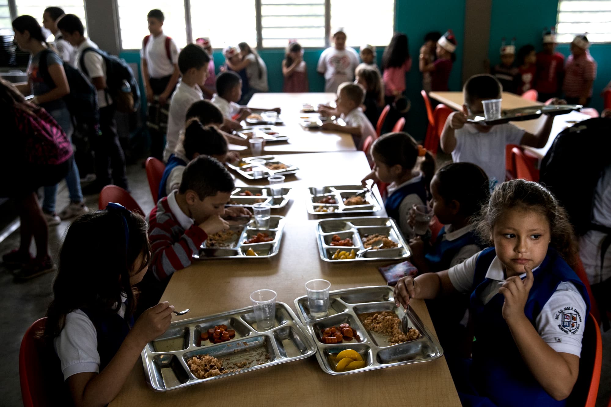 Students at the Jose R. Barreras school eat lunch in a dark cafeteria