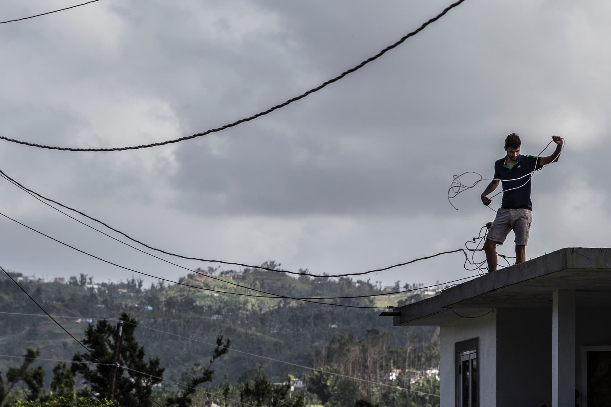 A man works on his home in Morovis, Puerto Rico, as residents in the neighborhood await for power to come back on.