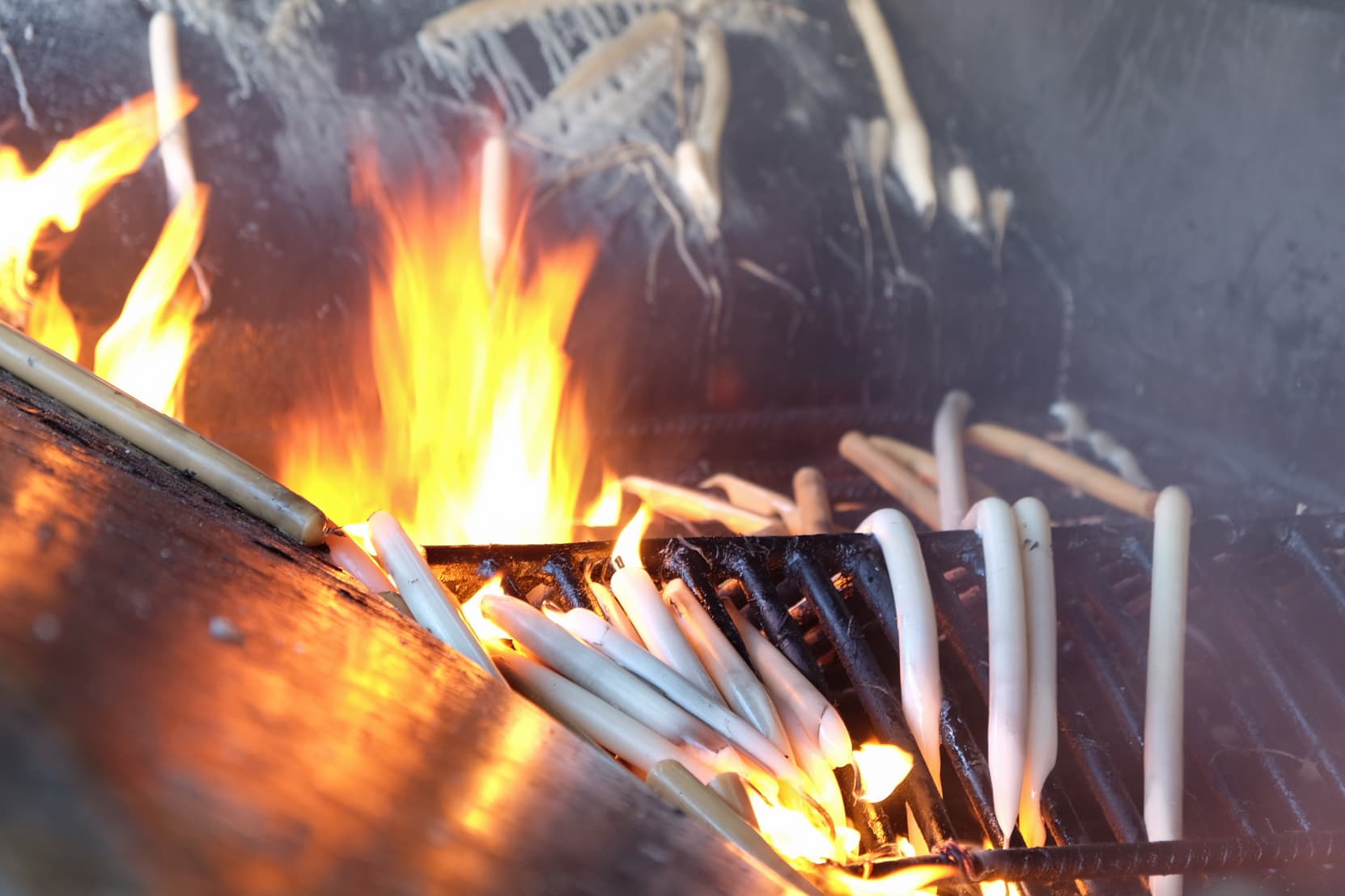 Prayer candles burn in the metal fire pit at the Shrine of Fatima.