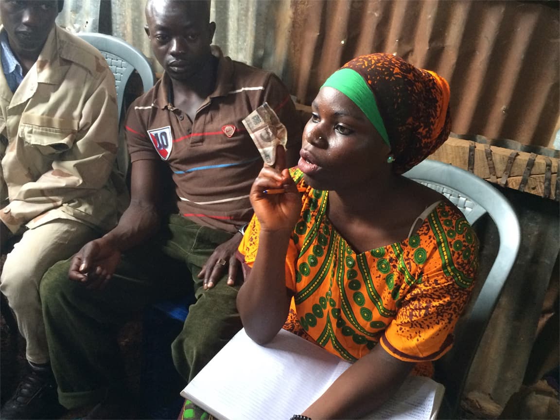 Miriam Sabit collects cash deposits from members of the Mashujaa savings group in Kibera. Members pool their savings to offer loans to group members wanting to start their own businesses.