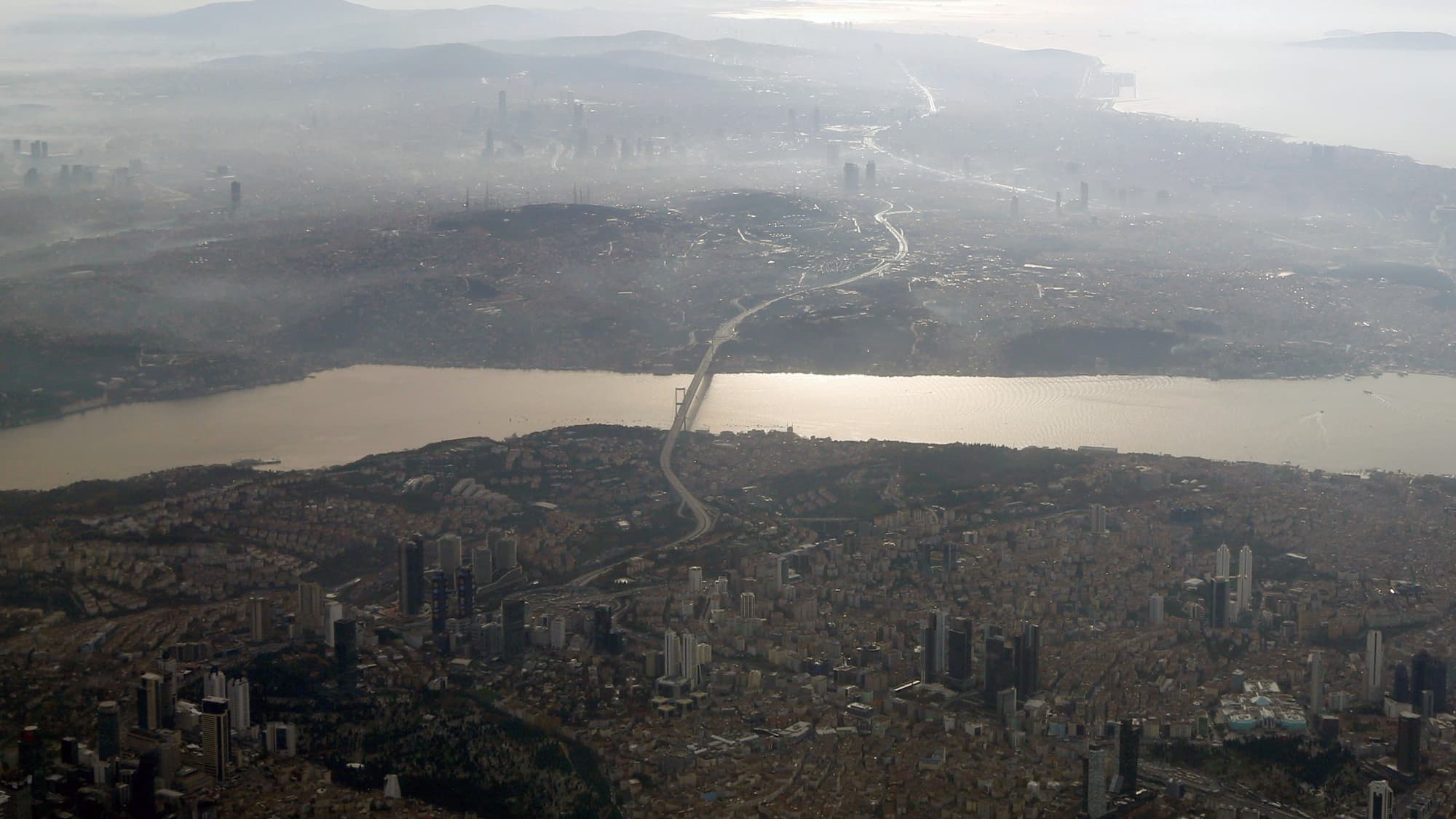 A river winds through a city full of buildings and skyscrapers.