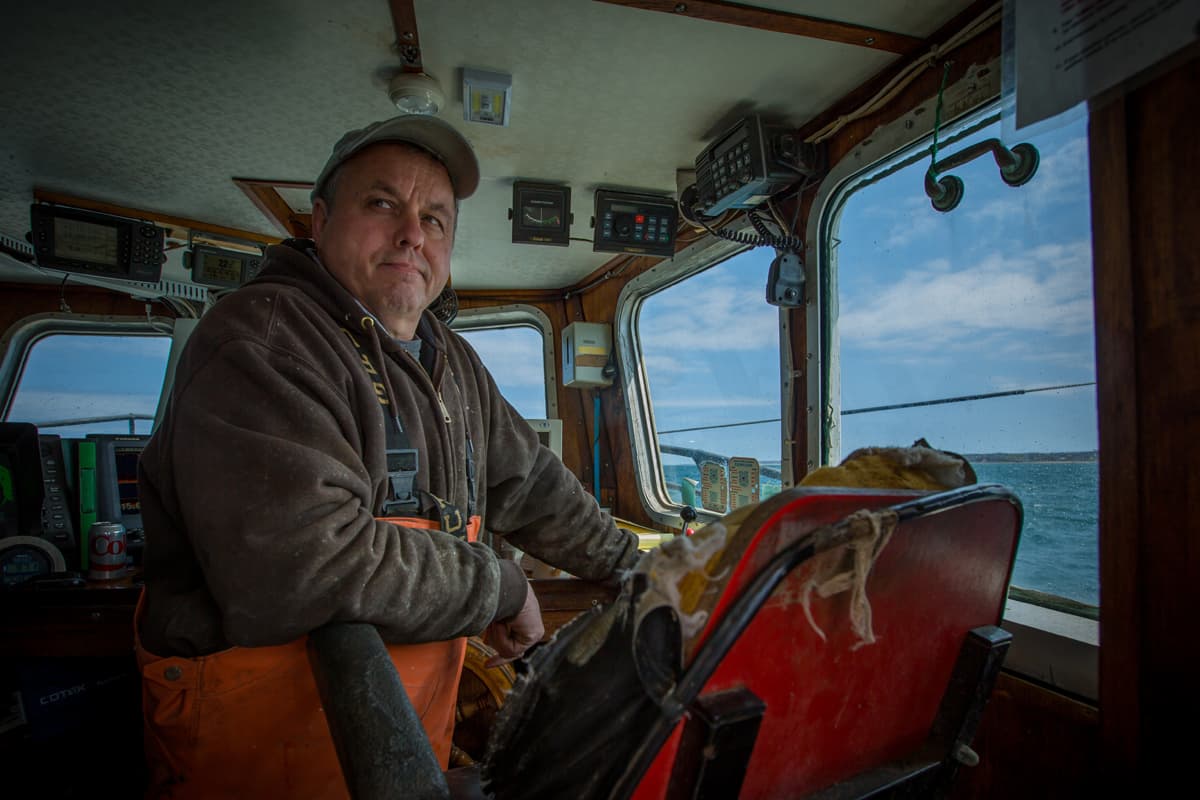 Captain Christopher Brown monitors activity on the back deck of the F/V Proud Mary while fishing in Rhode Island Sound.