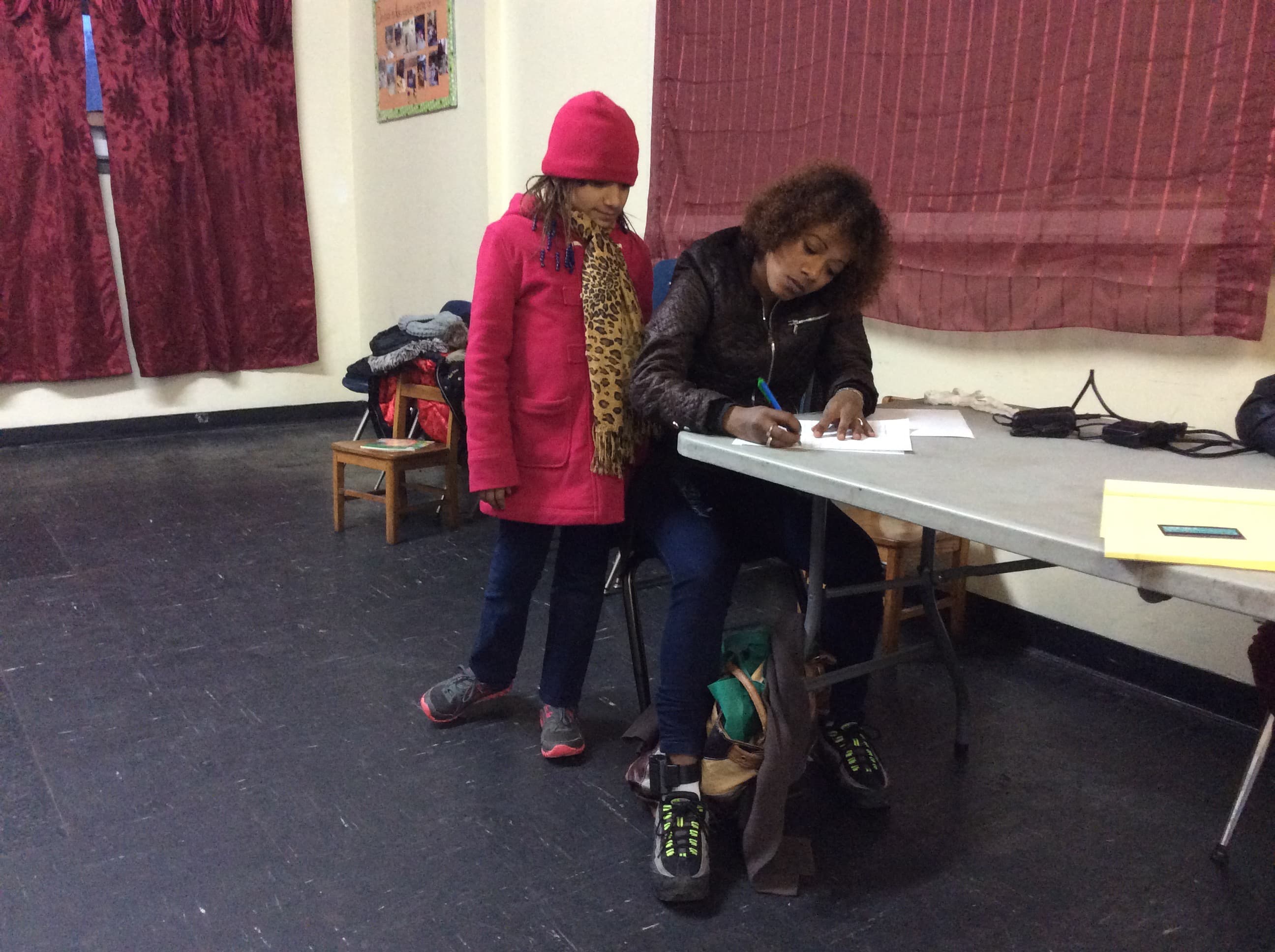 Julia fills out forms at Gregoria Flores' immigration clinic with daughter Nazary.