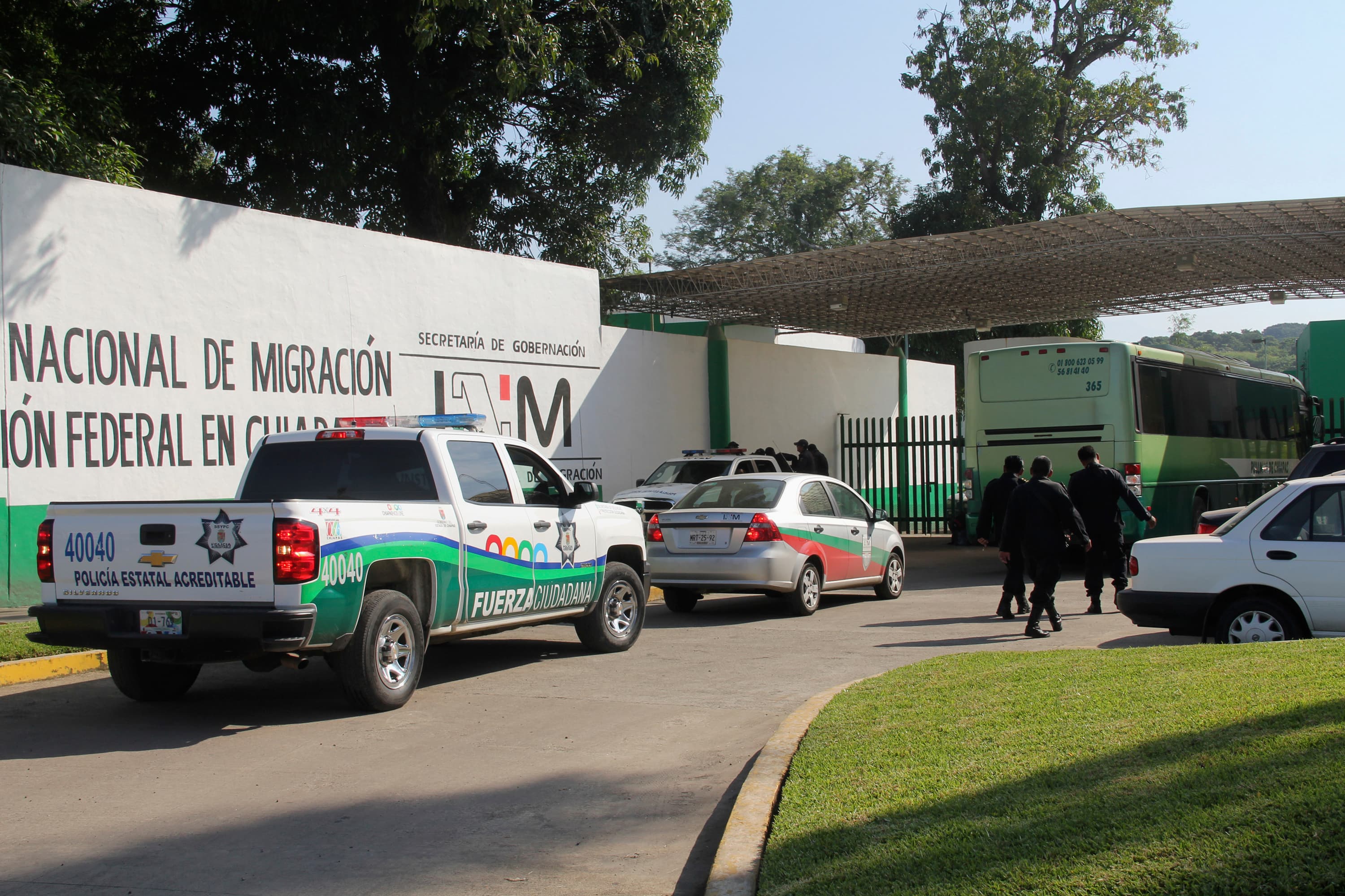 Trucks and police officers in front of small building