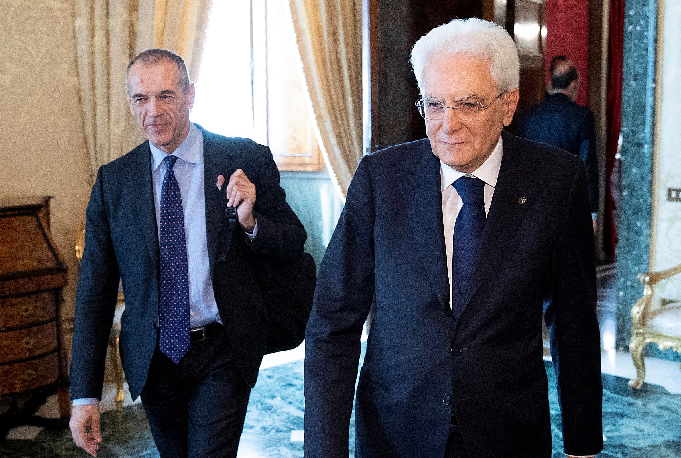 Carlo Cottarelli arrives for a meeting with the Italian President Sergio Mattarella walk next to each other