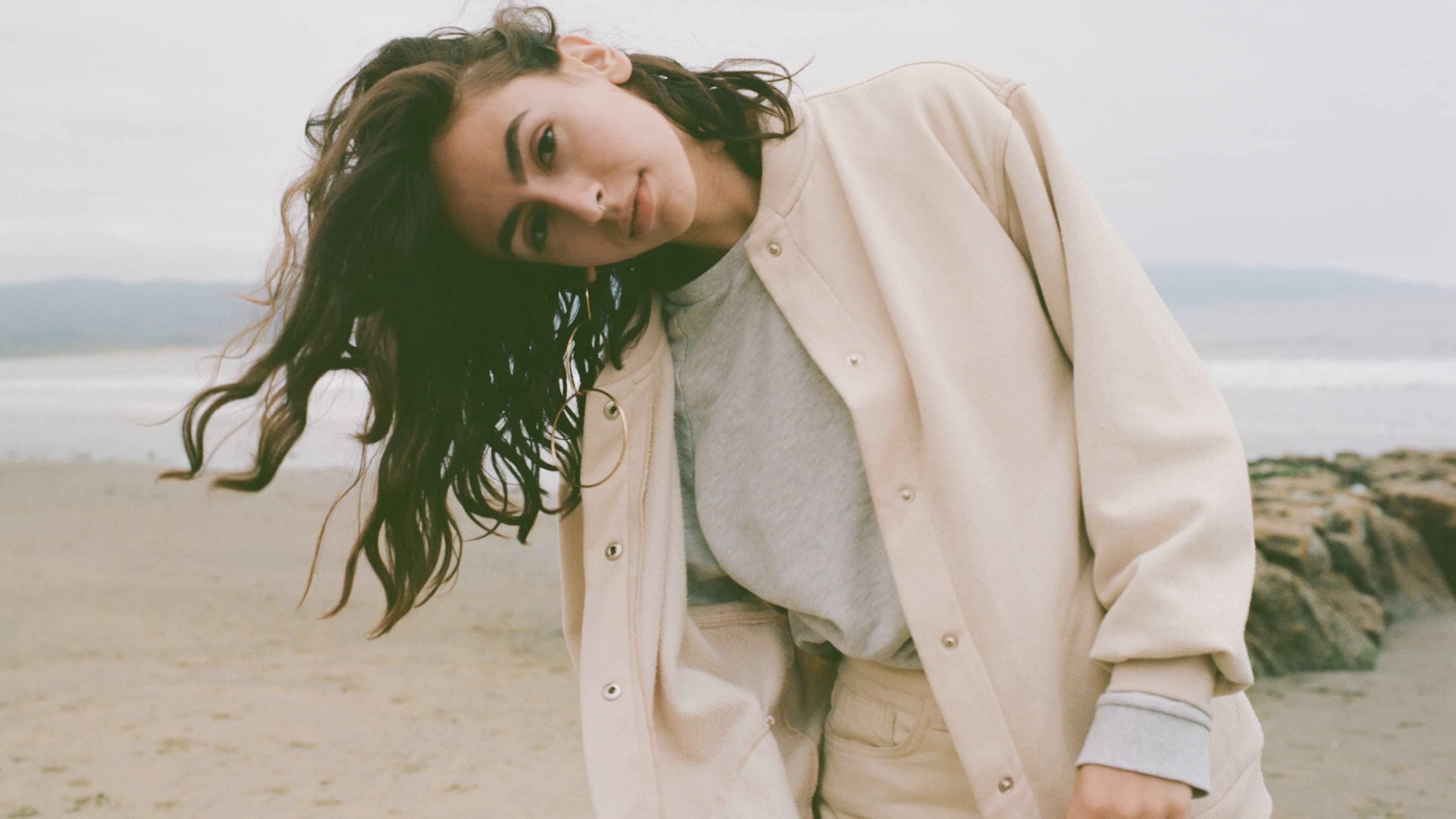 a woman with dark hair on a beach