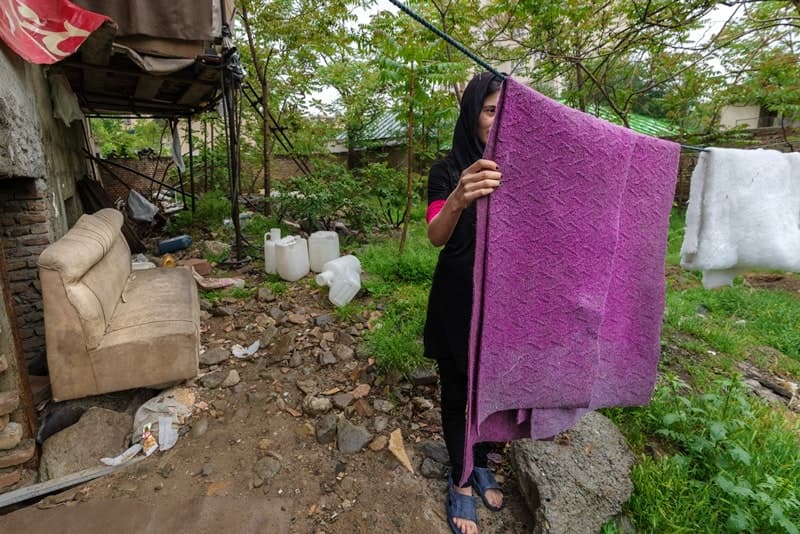 A woman hangs laundry on a clothes line