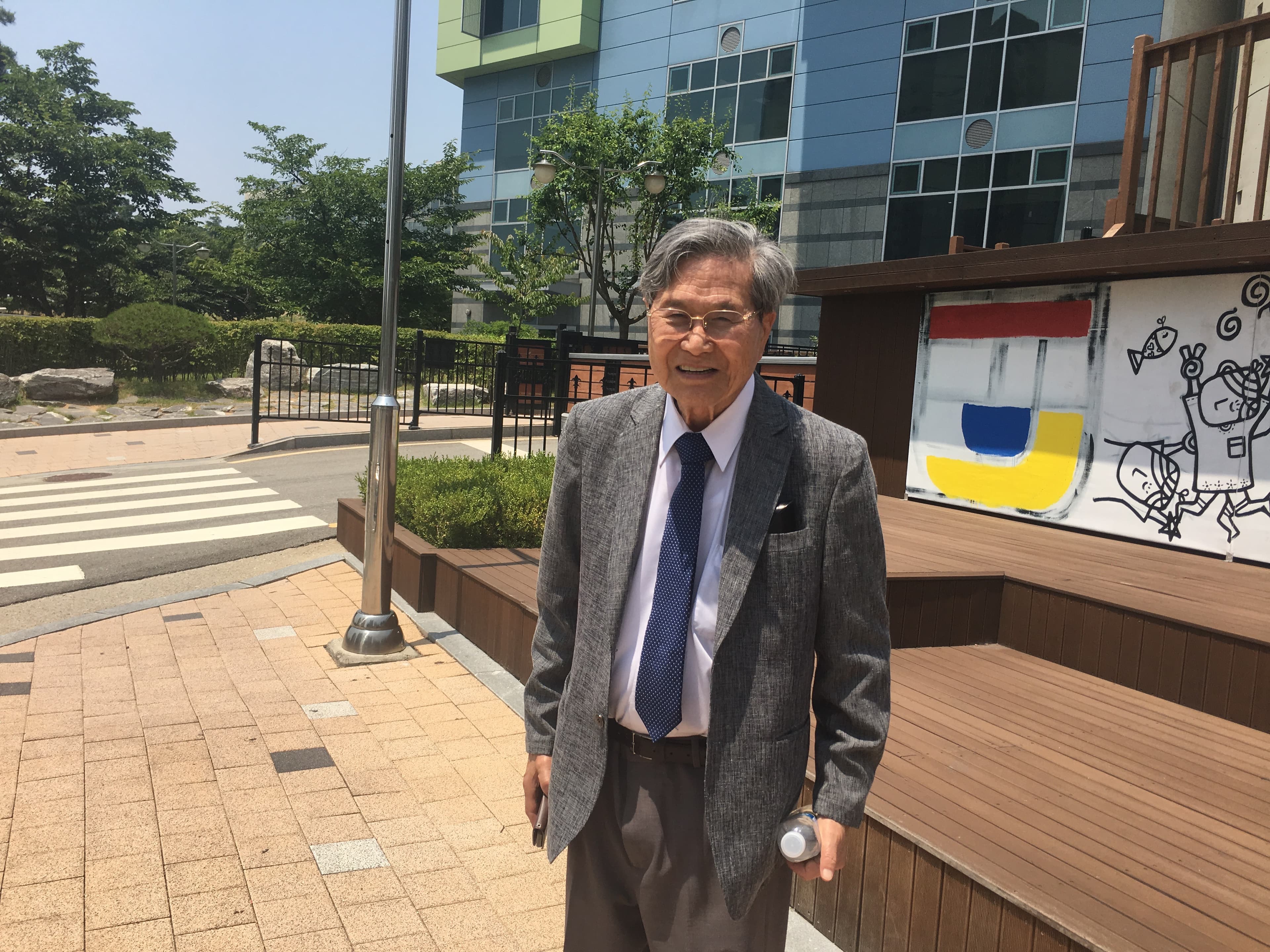 an old man smiling in a suit