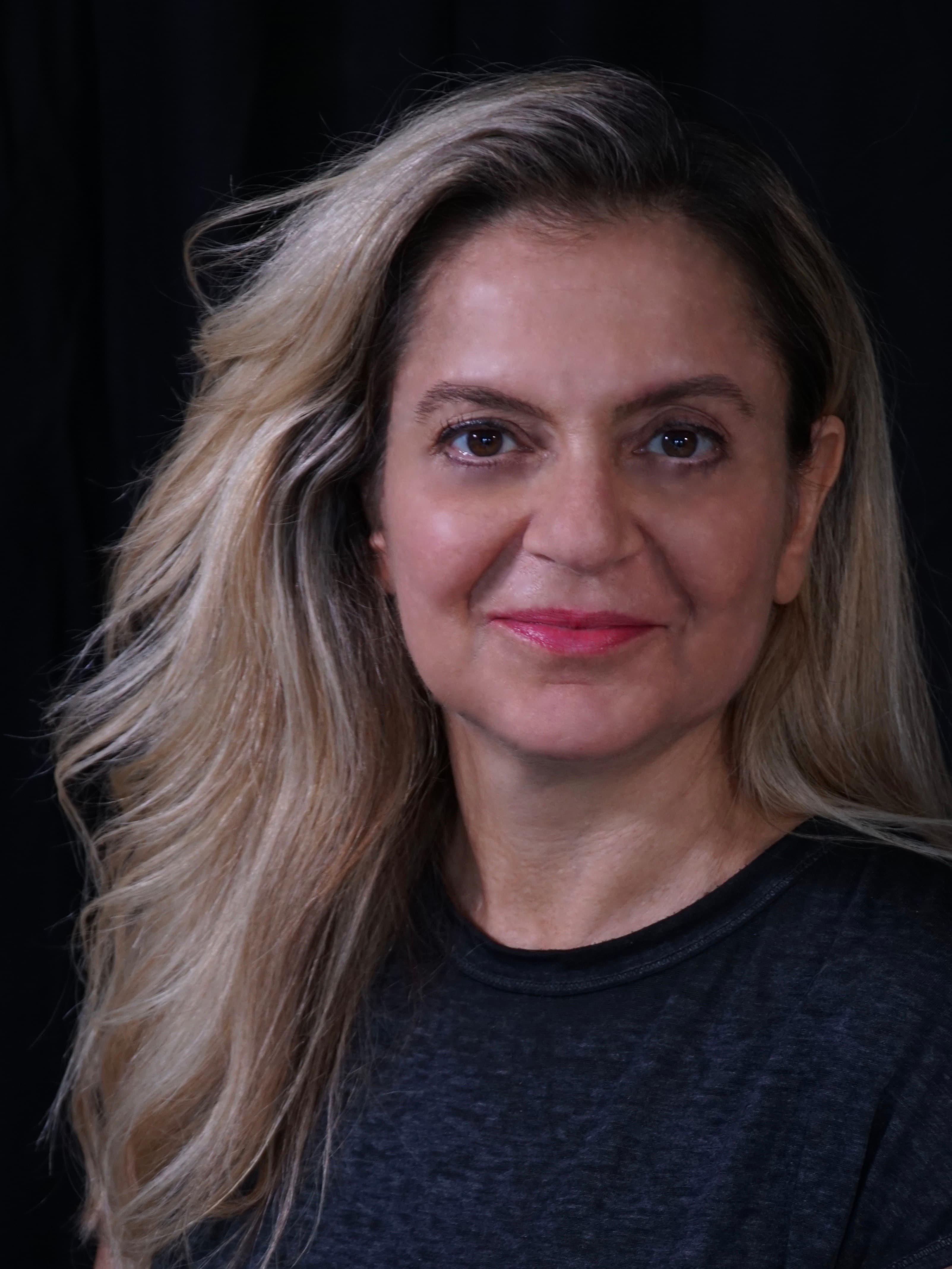Portait of woman smiling against black backdrop
