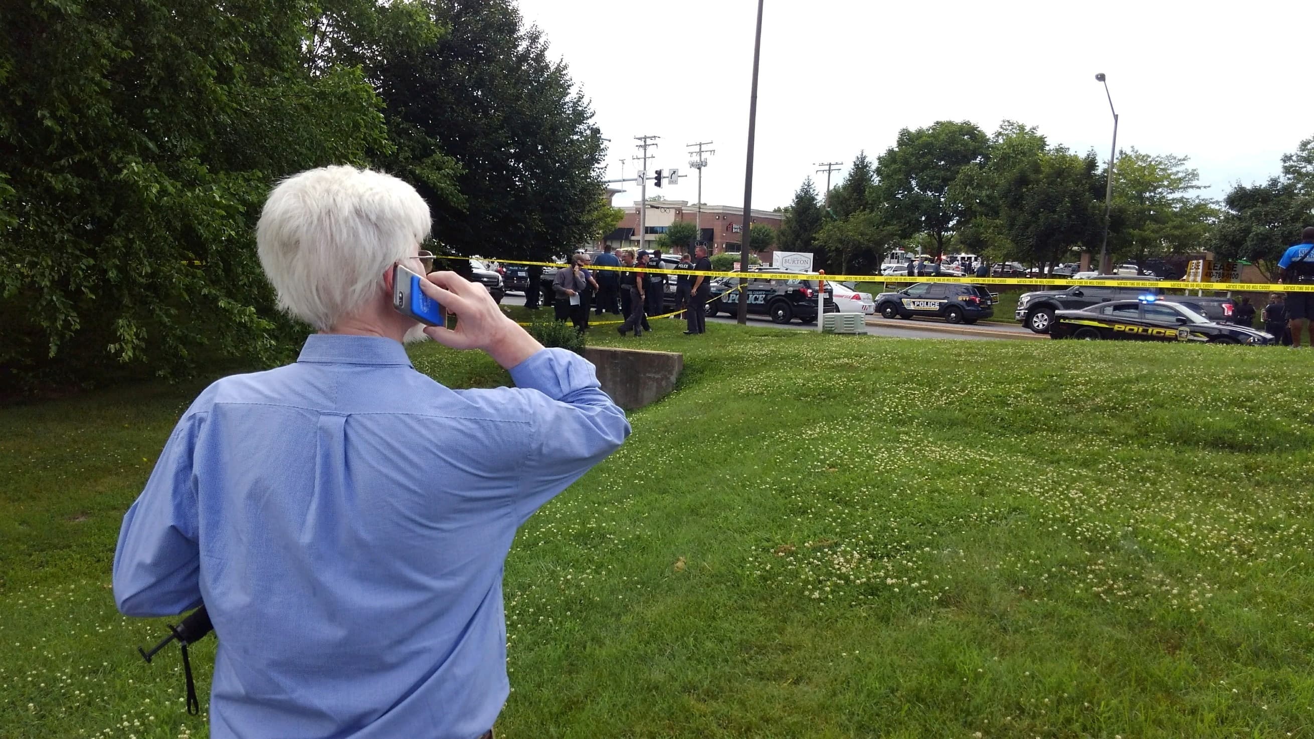 Journalist E.B Furgurson talk on the phone as police officers respond to an active shooter inside a city building at the Capital Gazette newspaper office in Annapolis, Maryland, U.S., June 28, 2018.