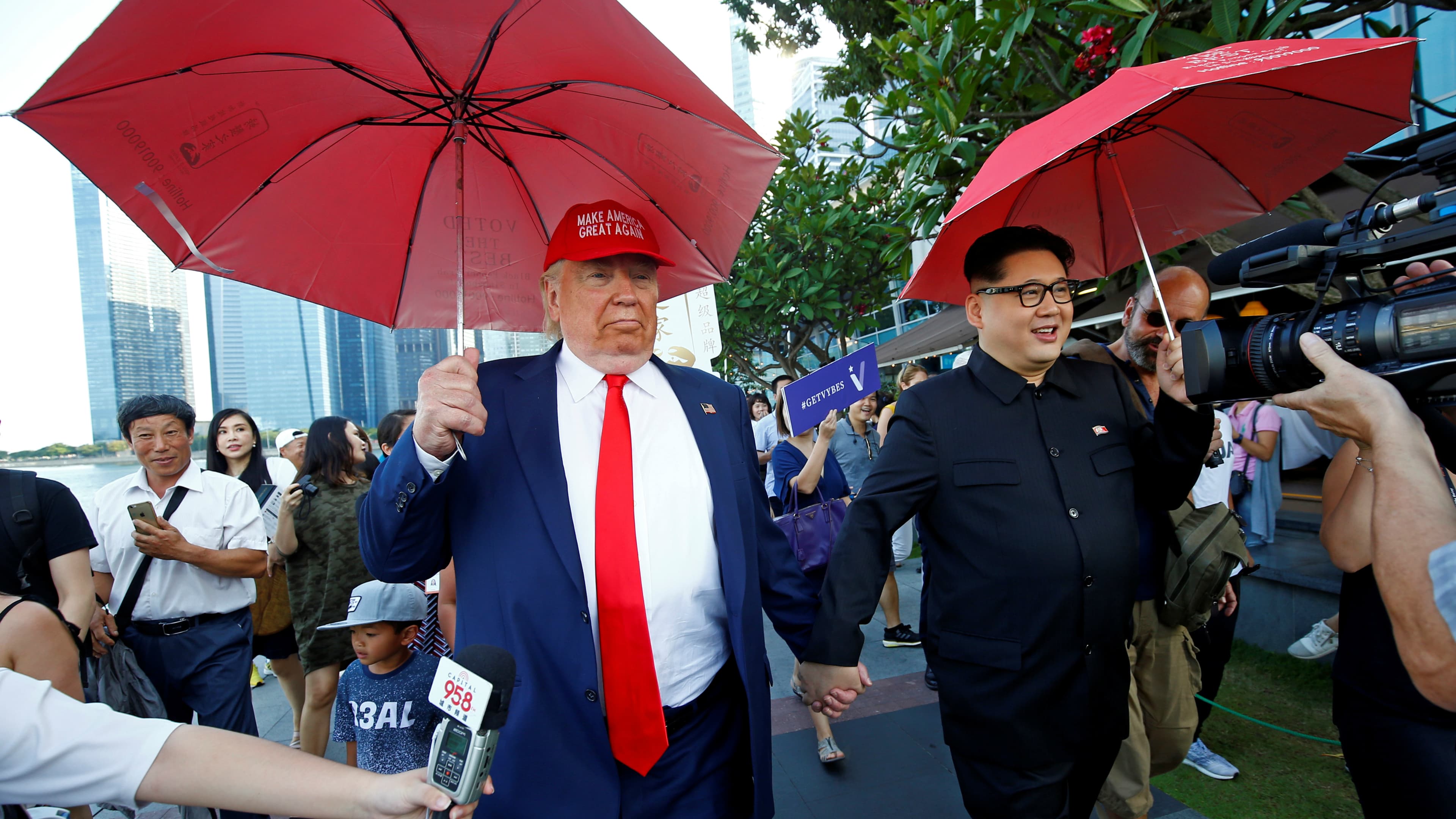 Men impersonating North Korean leader Kim Jong-un and US President Donald Trump meet at Merlion Park in Singapore, June 8, 2018.