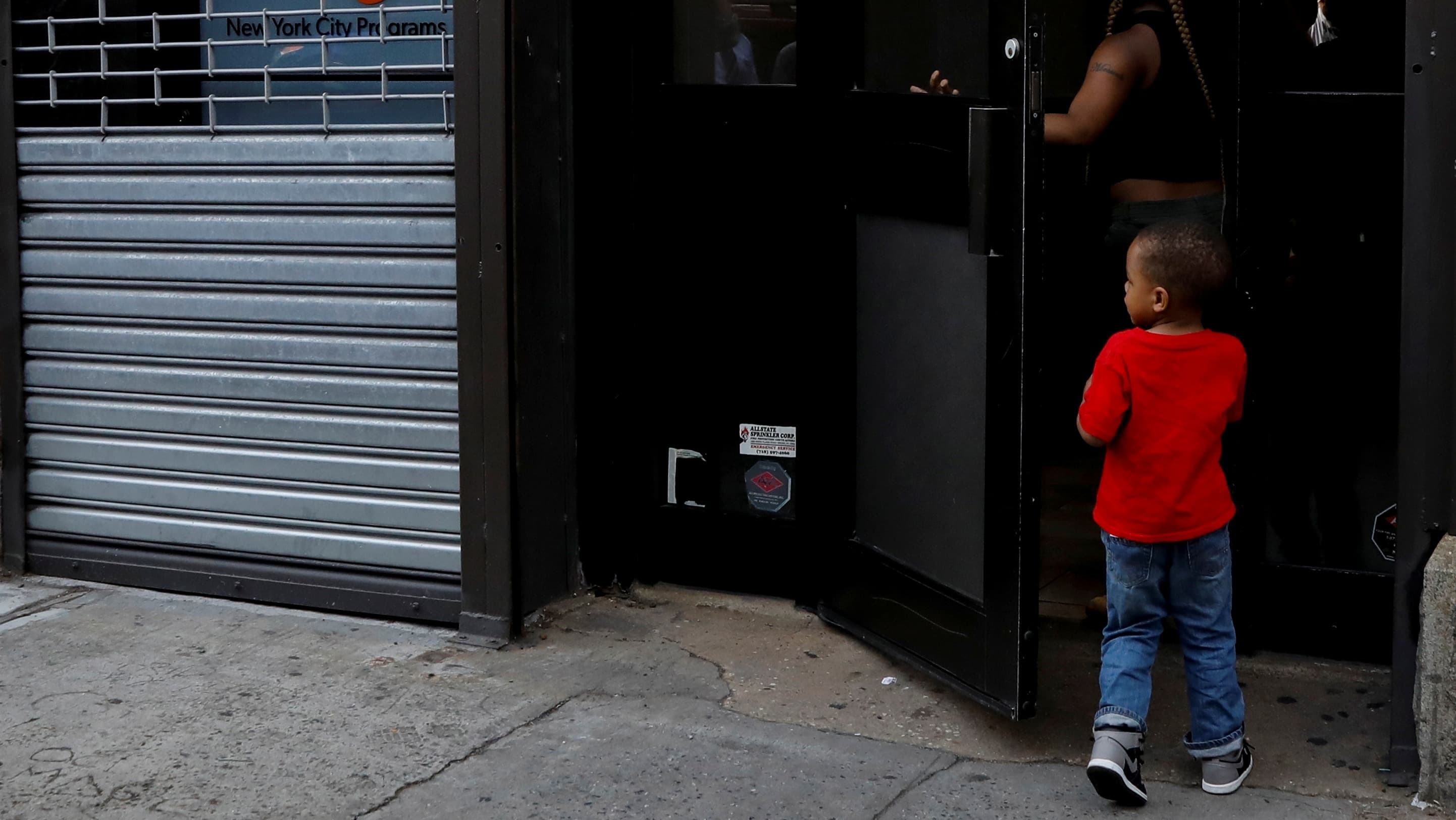 Young boy entering building from sidewalk