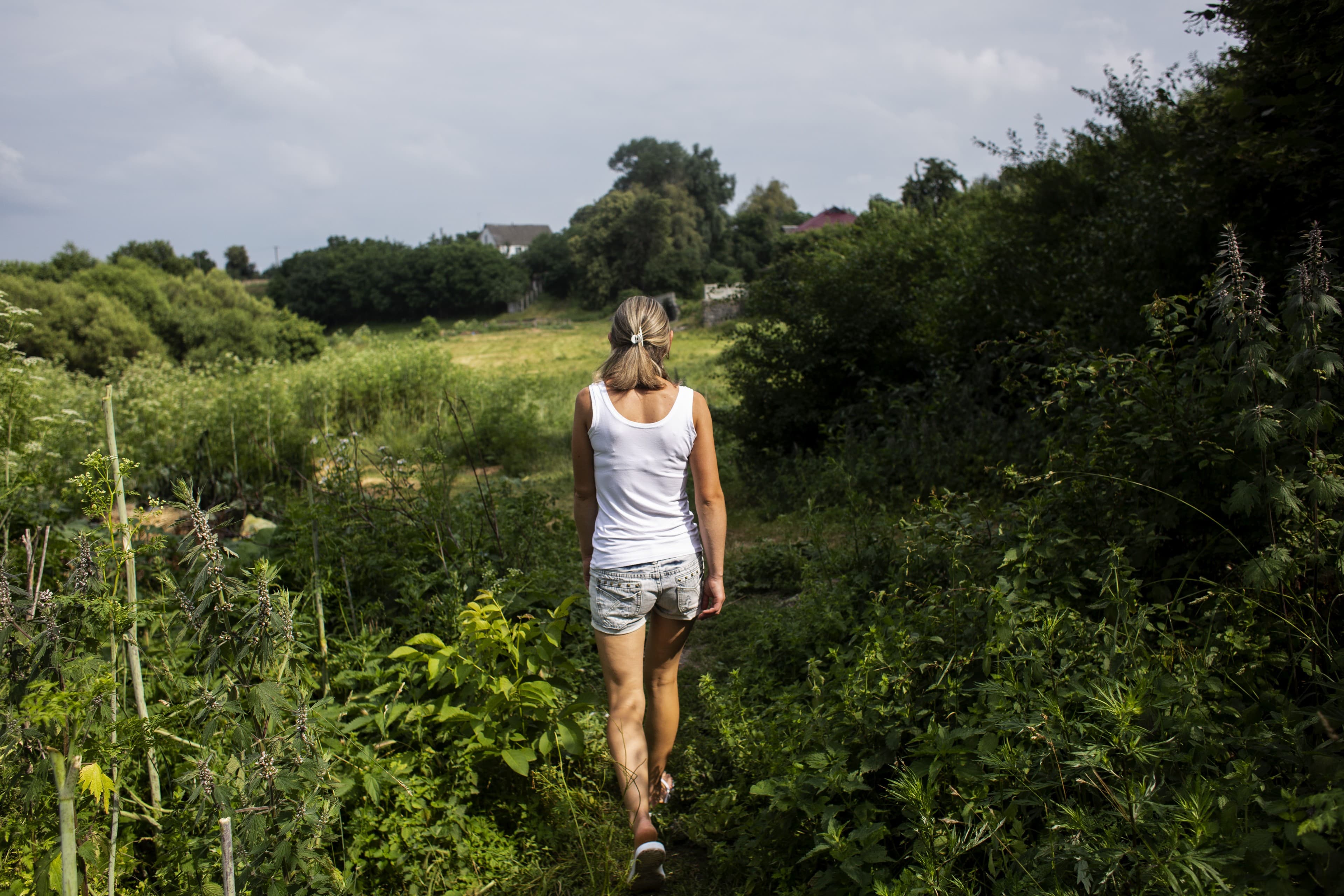 A woman walking towards a lake