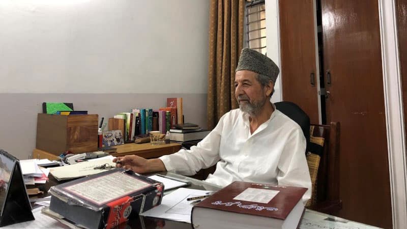 A man sits behind a desk