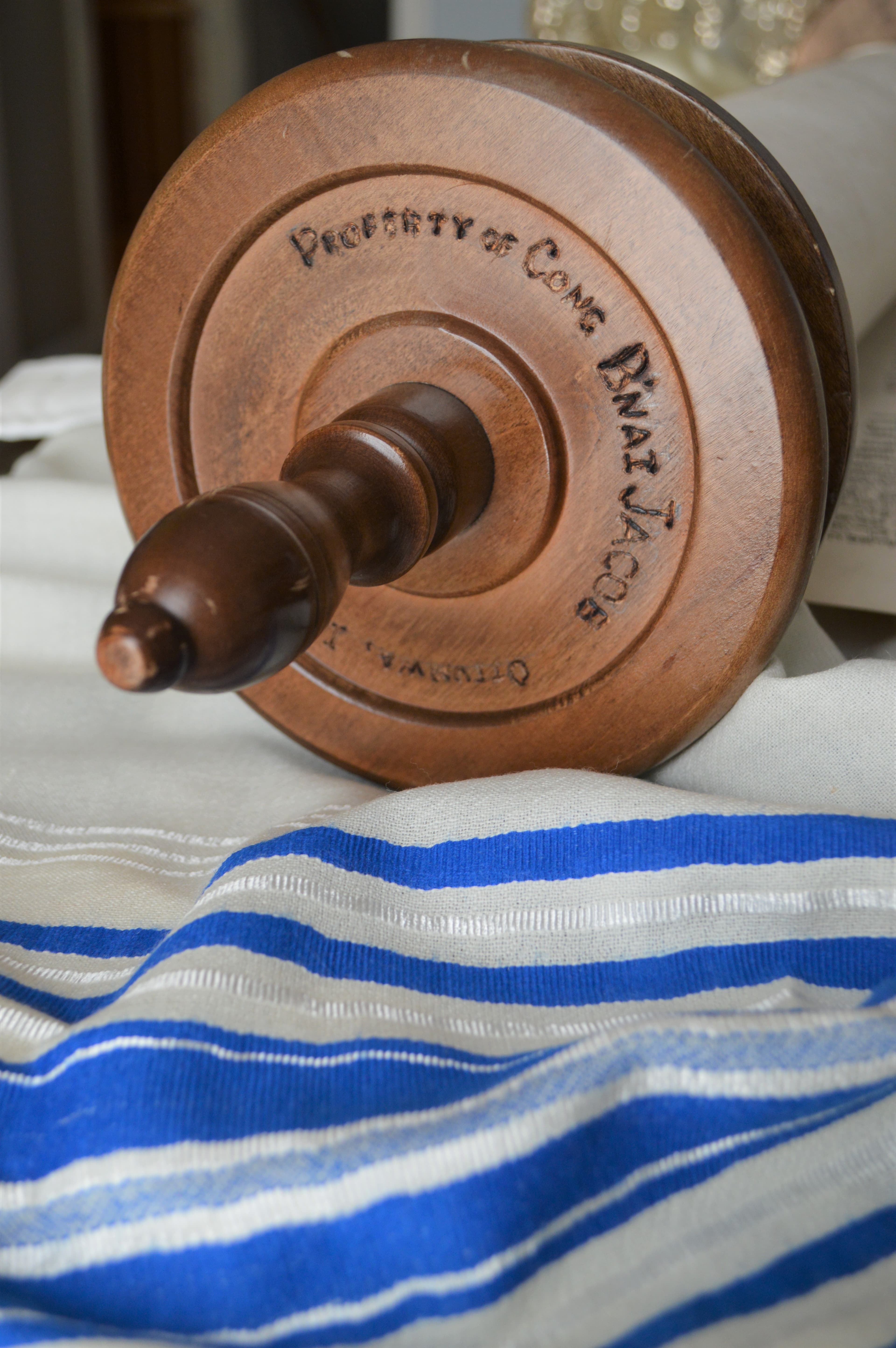 Close-up of the end of of a scroll, sitting on a blue and white striped cloth