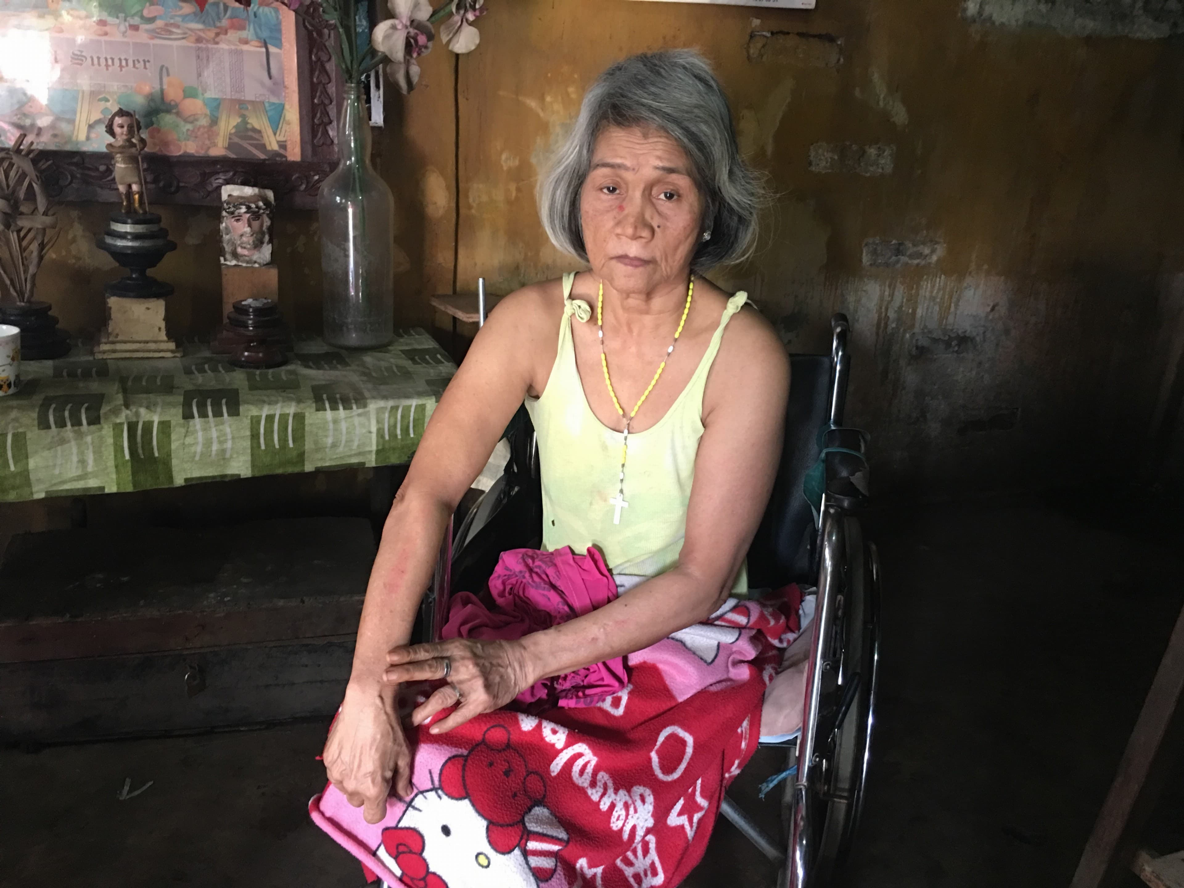 an older woman with a pink skirt sitting in a wheelchair