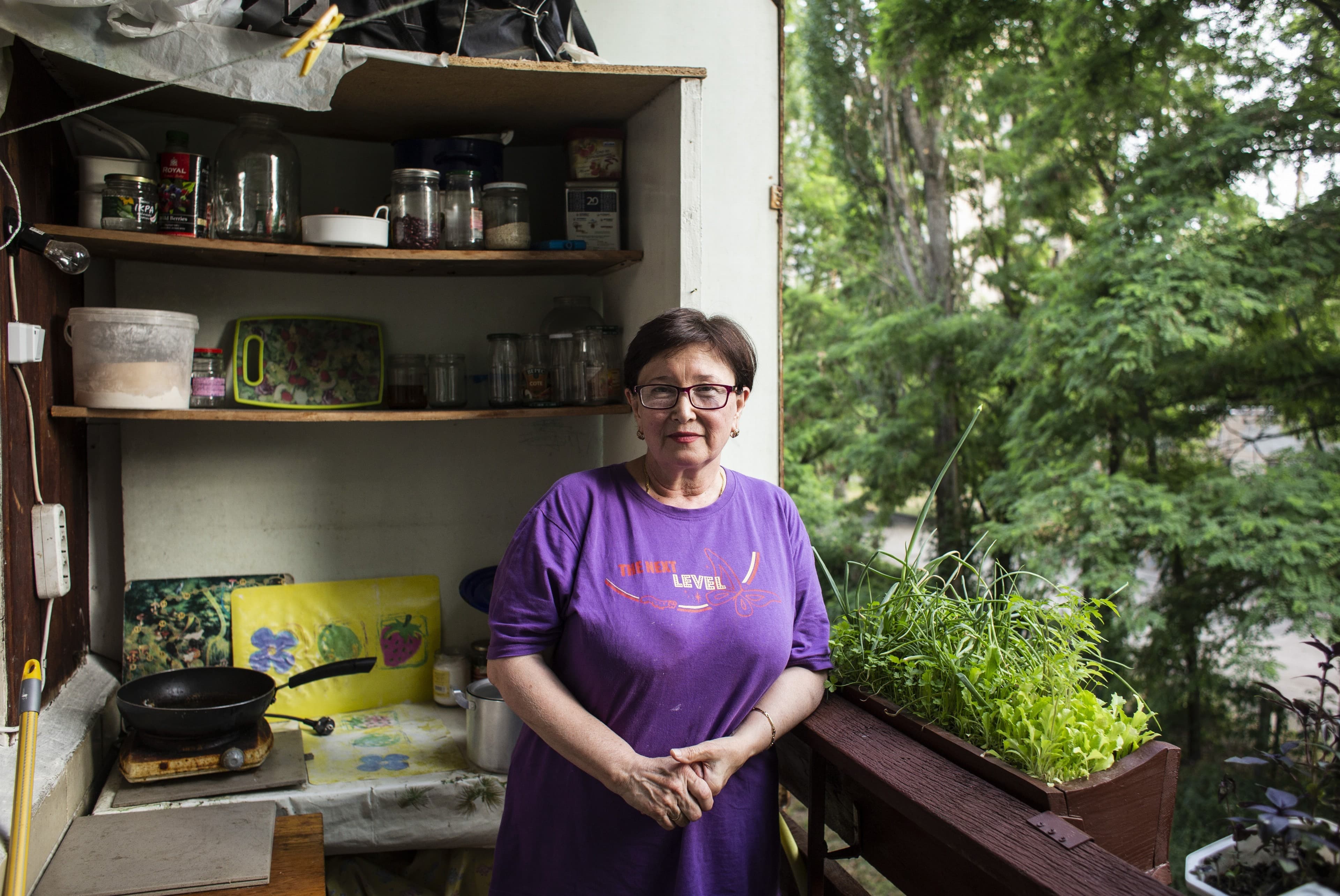 A woman sits by a stove