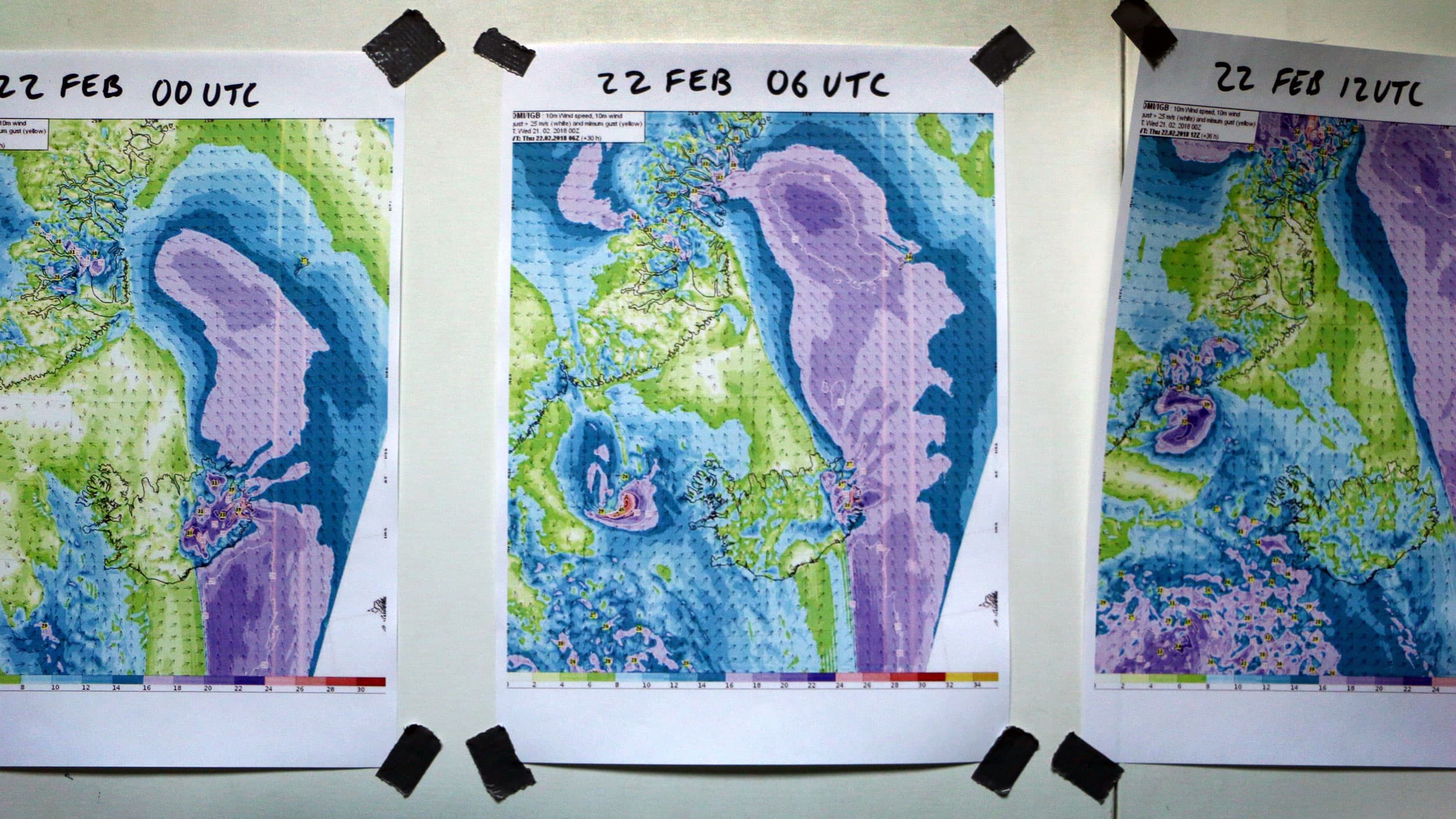 Color maps depicting wind velocities are taped to a wall and dated