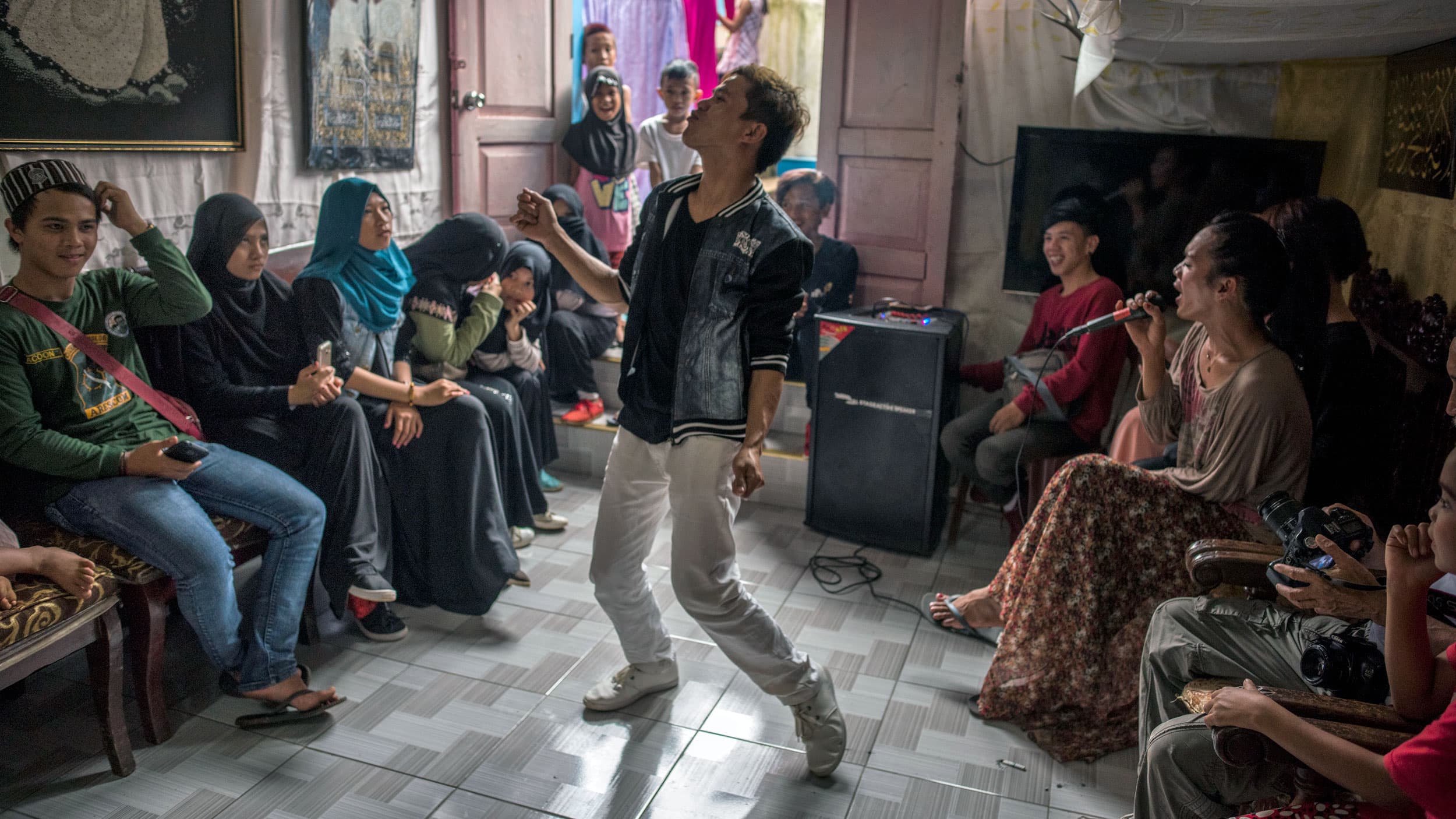 A man has his hands up as others laugh and smile around him