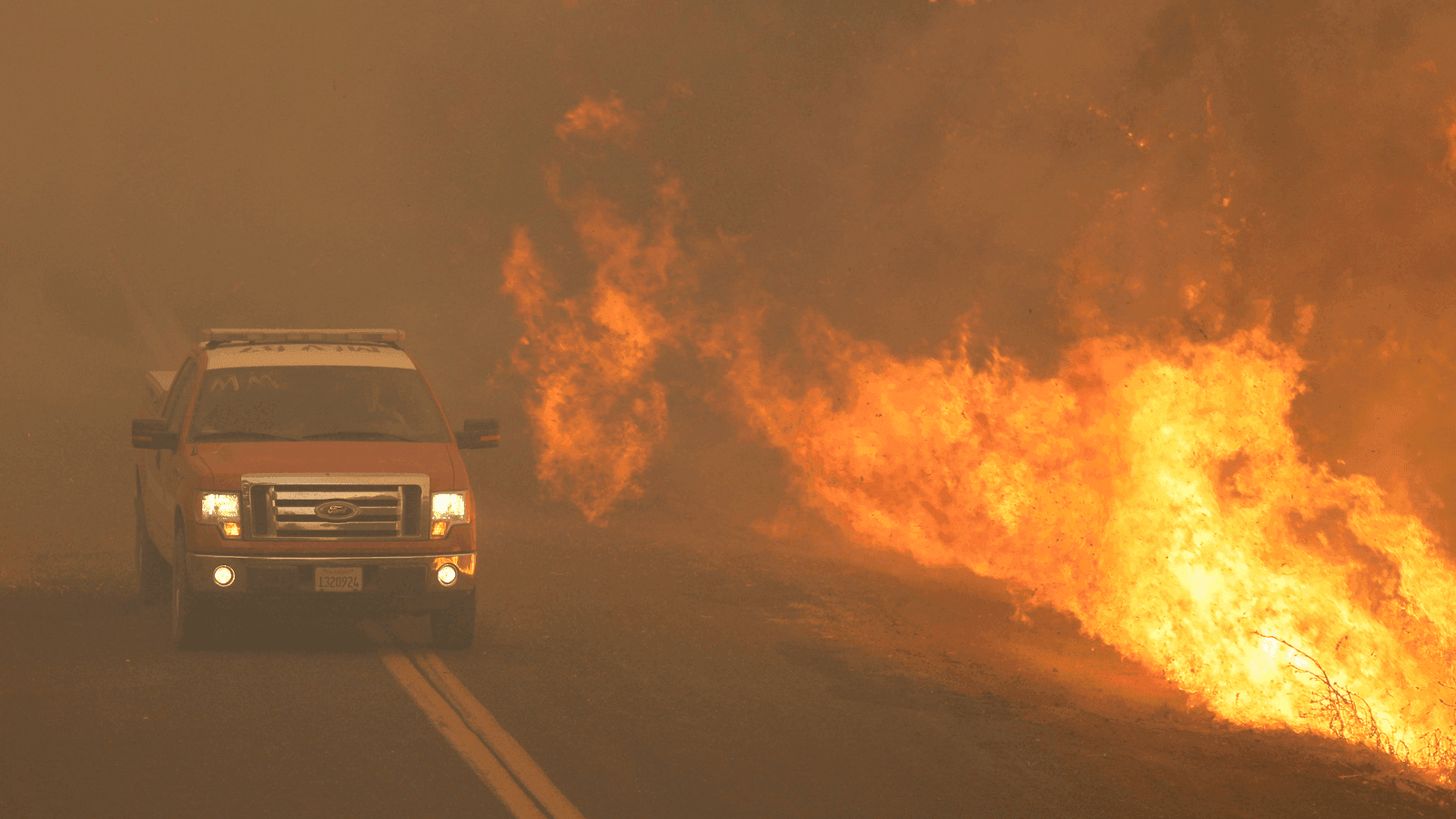 a firetruck next to a forest fire in california