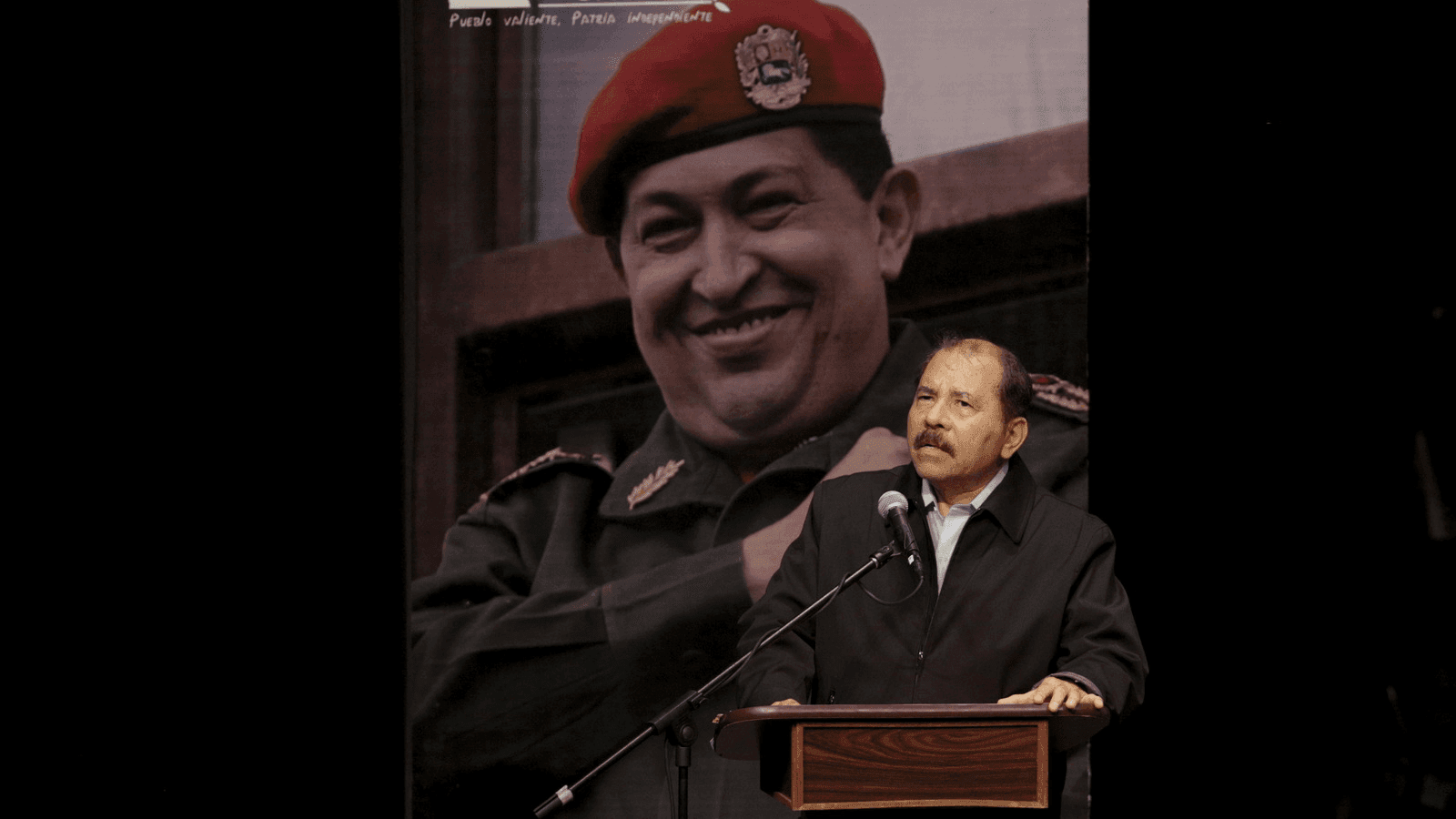 Daniel Ortega speaks in front of a huge picture of Hugo Chavez