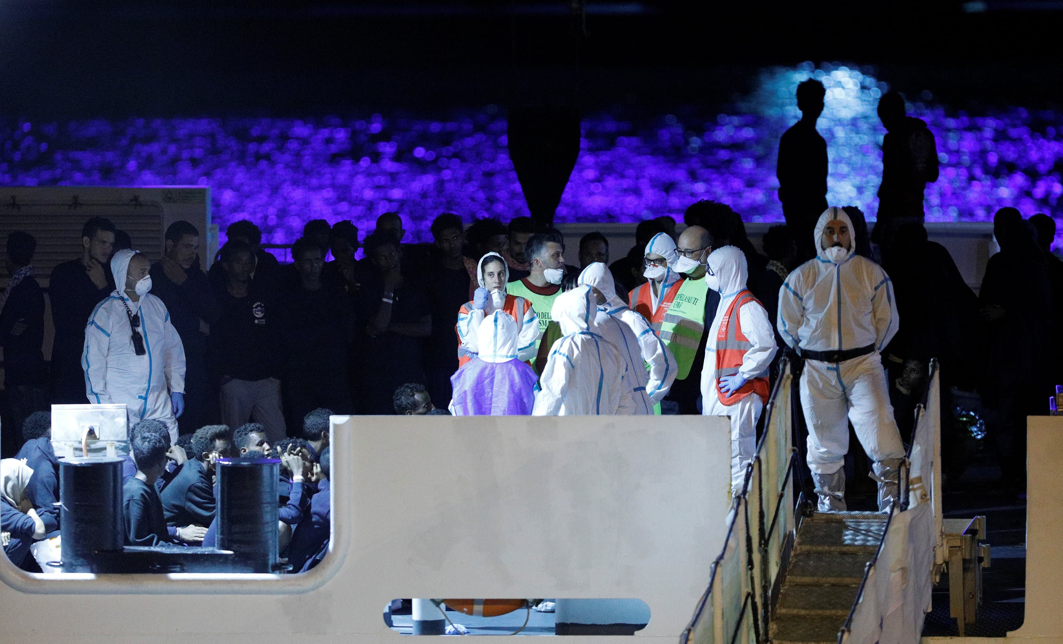people in white protective suits on a boat